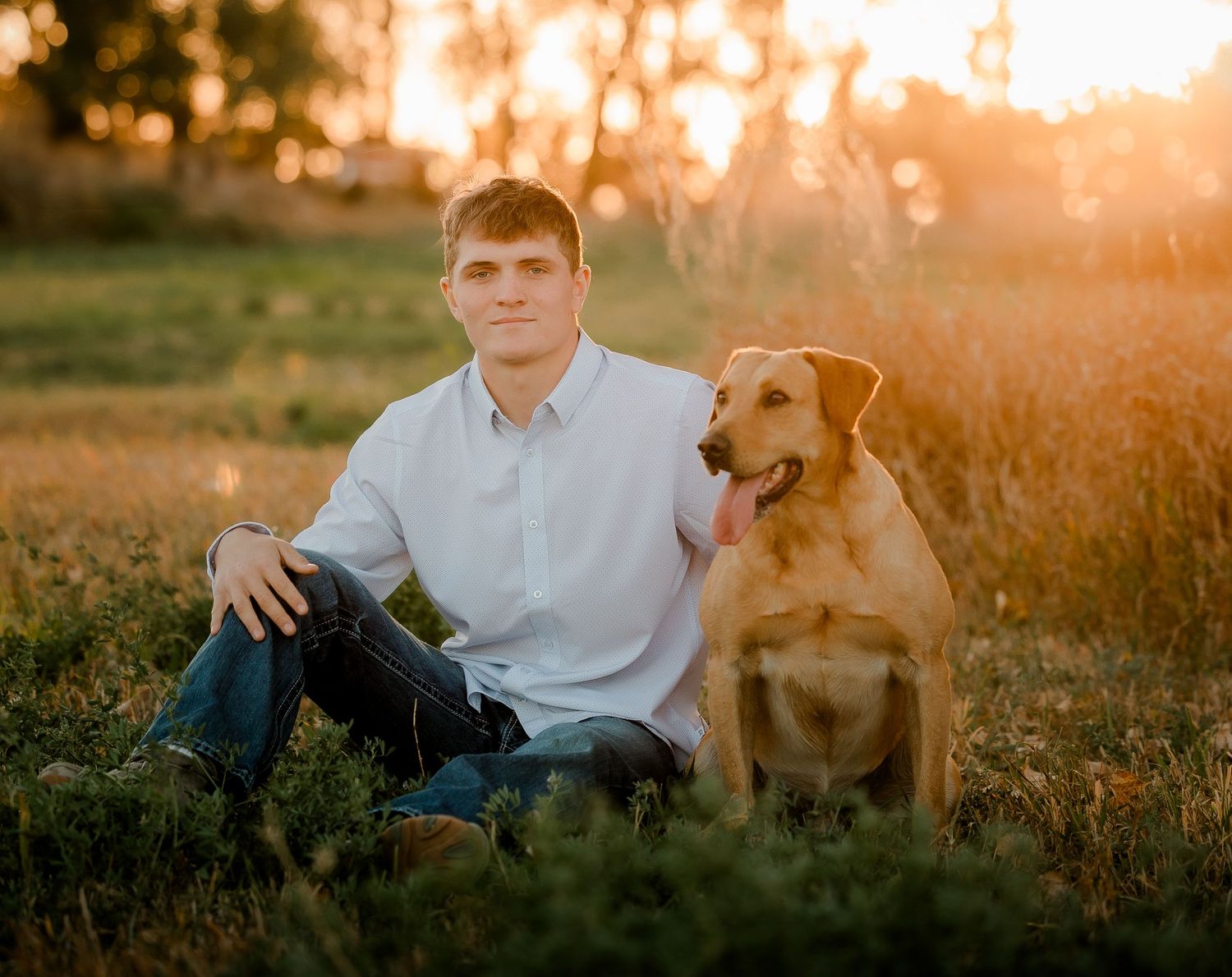 High school senior boy on family farm near Willow Lake, South Dakota with tractor and hunting gear