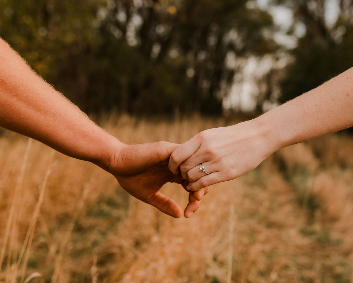 Engaged couple during fall photo session near Redfield, South Dakota with bride in red dress
