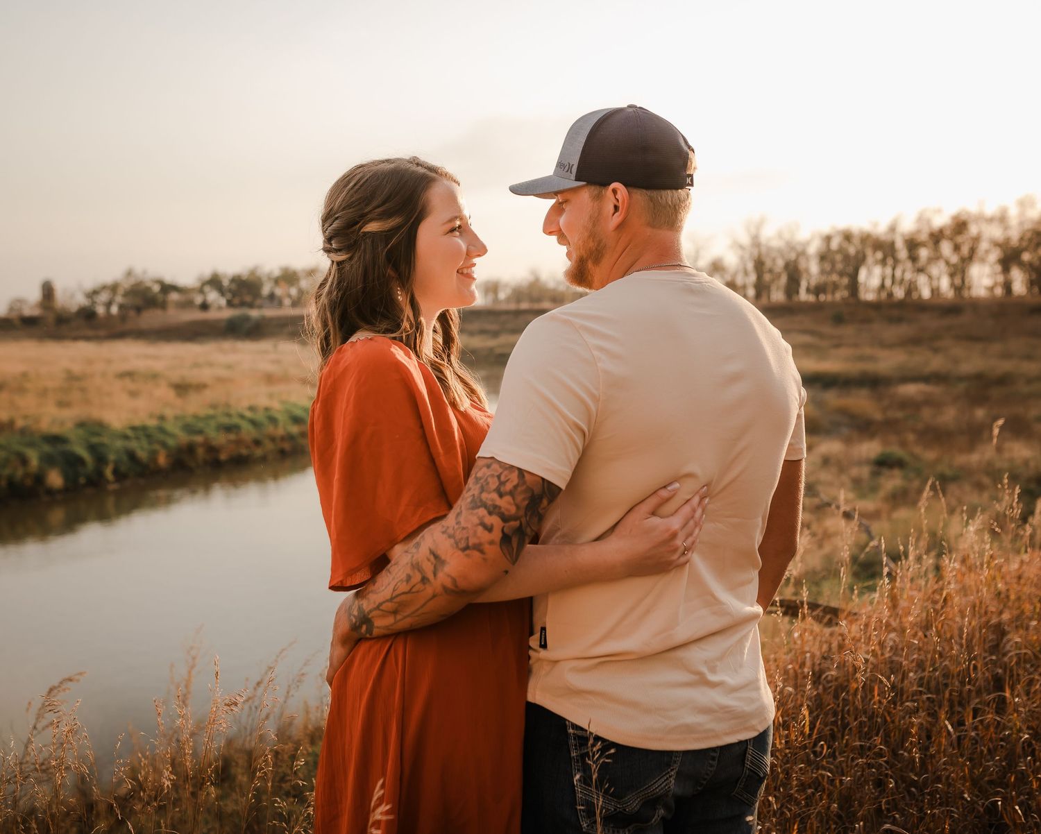 Engaged couple during fall photo session near Redfield, South Dakota with bride in red dress