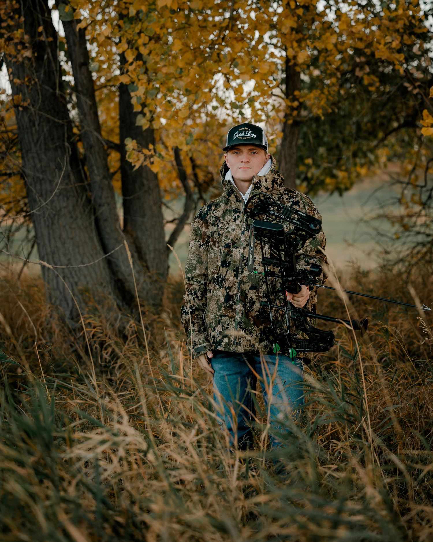 High school senior boy on family farm near Willow Lake, South Dakota with tractor and hunting gear