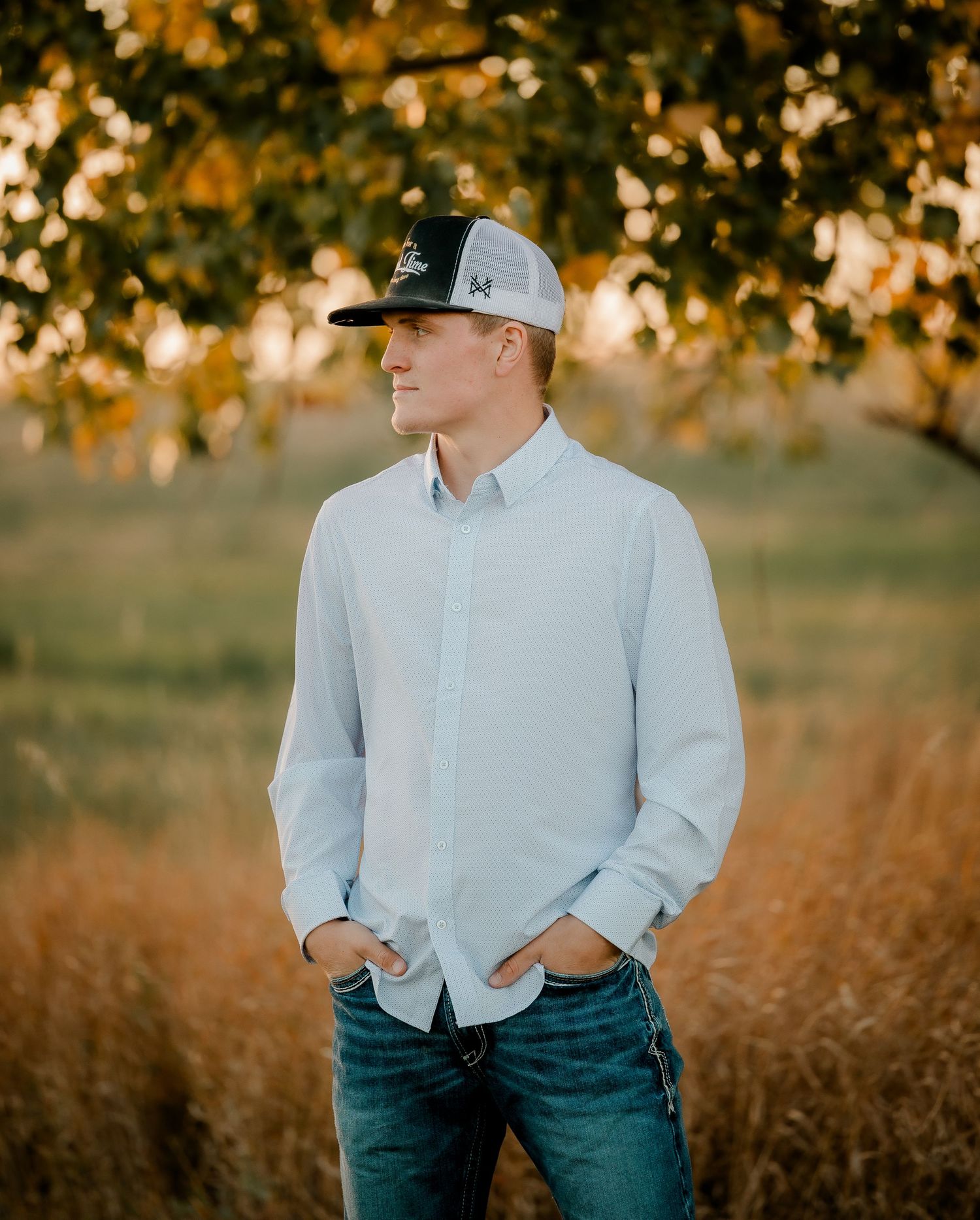 High school senior boy on family farm near Willow Lake, South Dakota with tractor and hunting gear