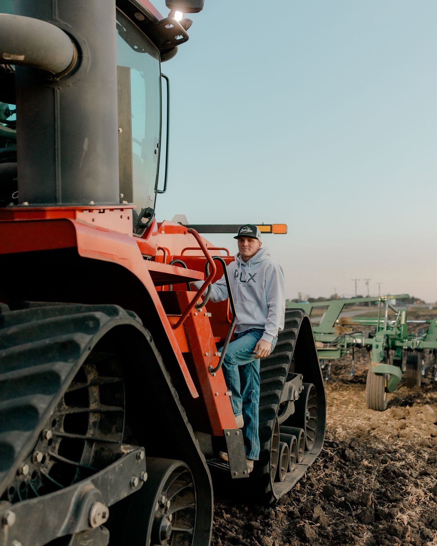 High school senior boy on family farm near Willow Lake, South Dakota with tractor and hunting gear