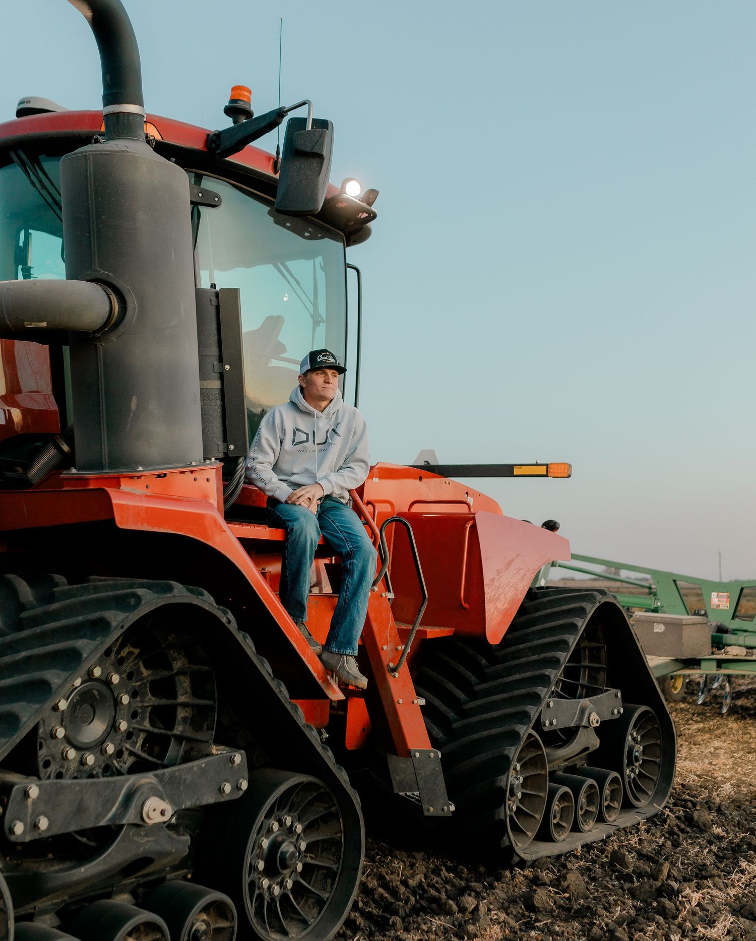 High school senior boy on family farm near Willow Lake, South Dakota with tractor and hunting gear