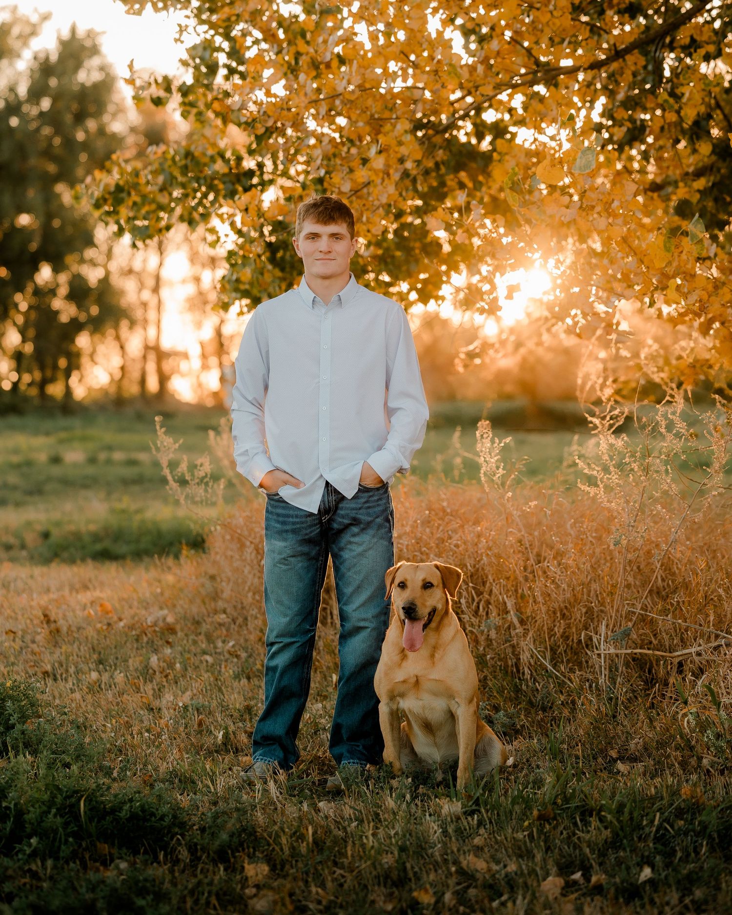 High school senior boy on family farm near Willow Lake, South Dakota with tractor and hunting gear