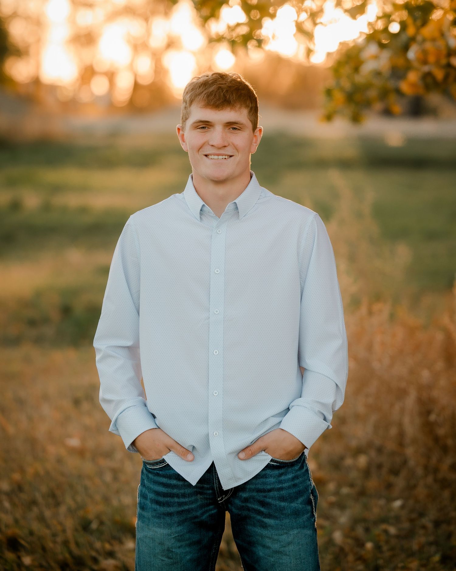 High school senior boy on family farm near Willow Lake, South Dakota with tractor and hunting gear