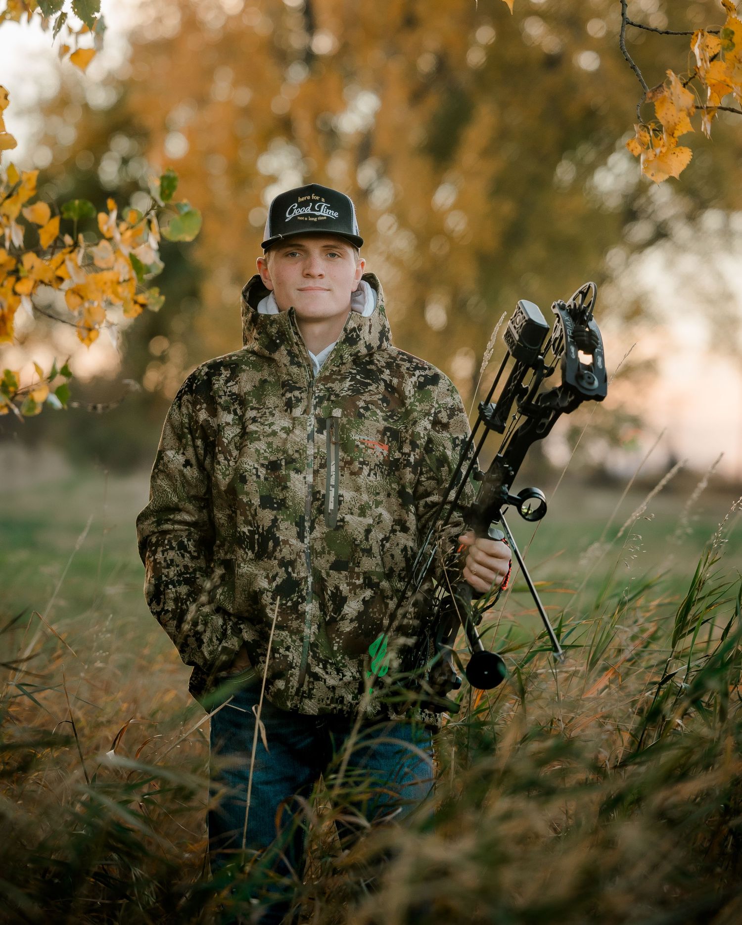 High school senior boy on family farm near Willow Lake, South Dakota with tractor and hunting gear