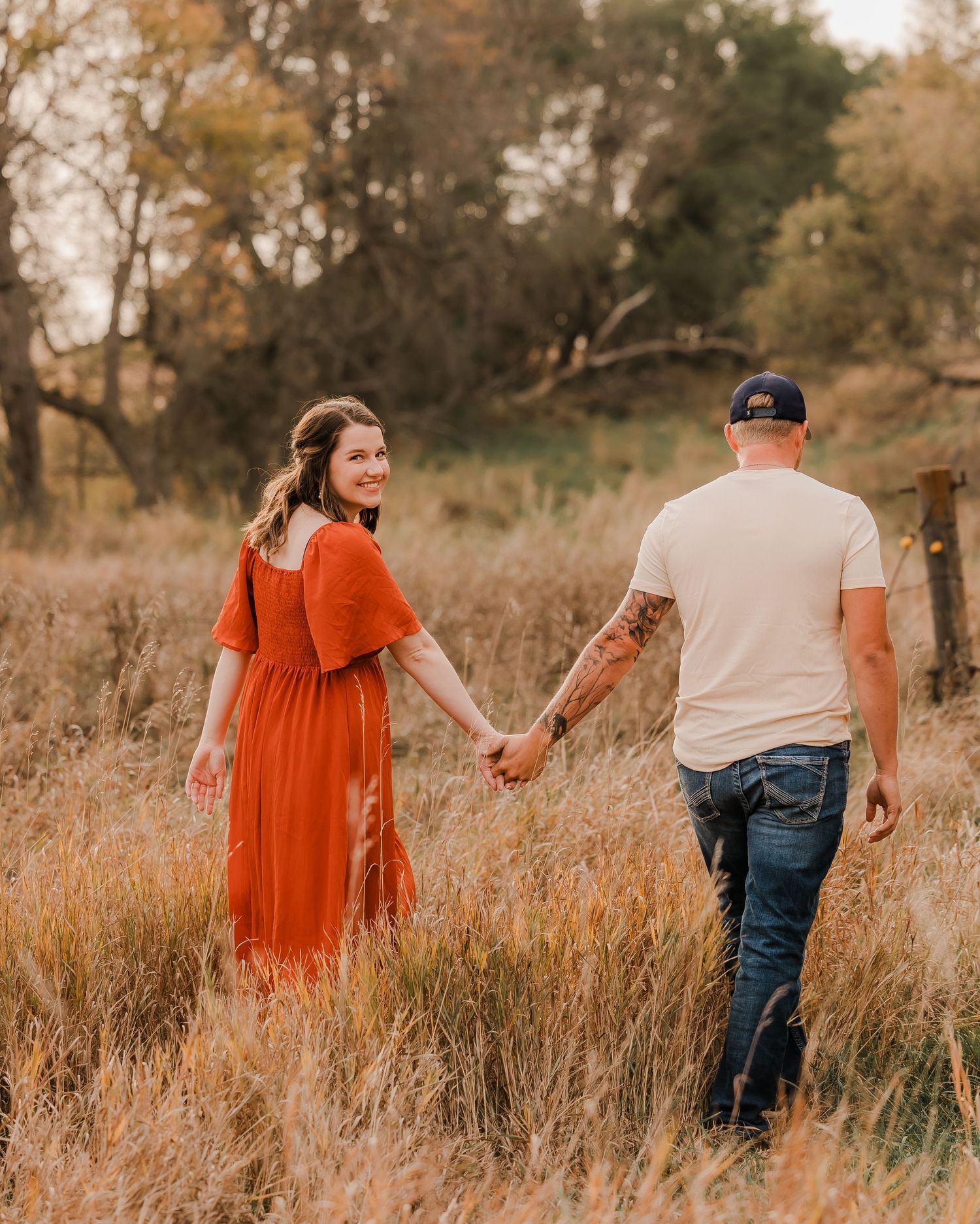 Engaged couple during fall photo session near Redfield, South Dakota with bride in red dress