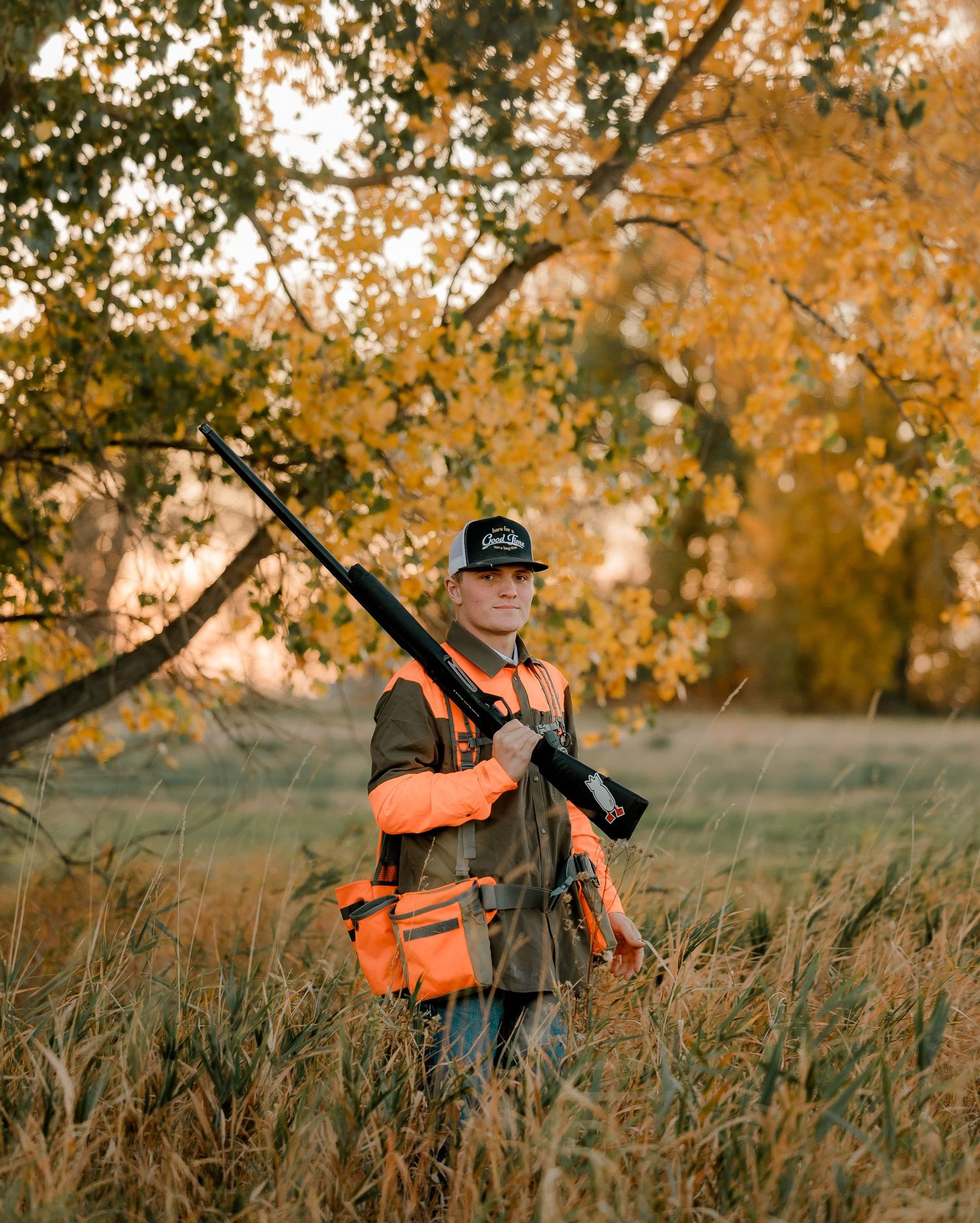 High school senior boy on family farm near Willow Lake, South Dakota with tractor and hunting gear