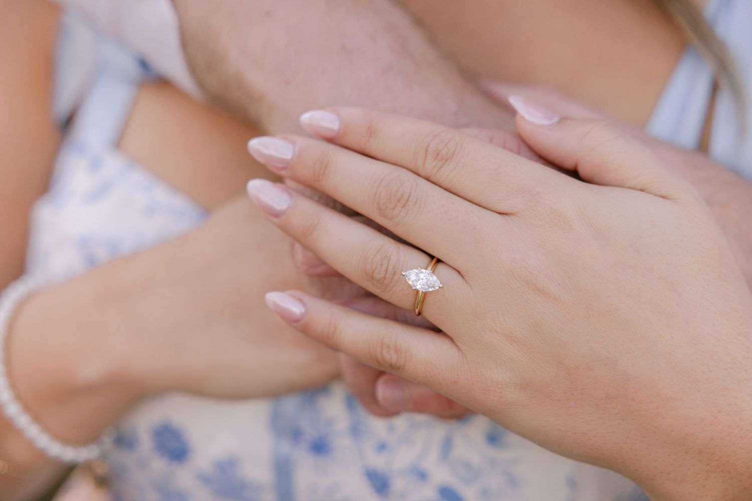 A man delicately holds the hand of a woman he just proposed to. Her stunning diamond ring is the focal point. LOUISIANA WEDDING PHOTOGRAPHER