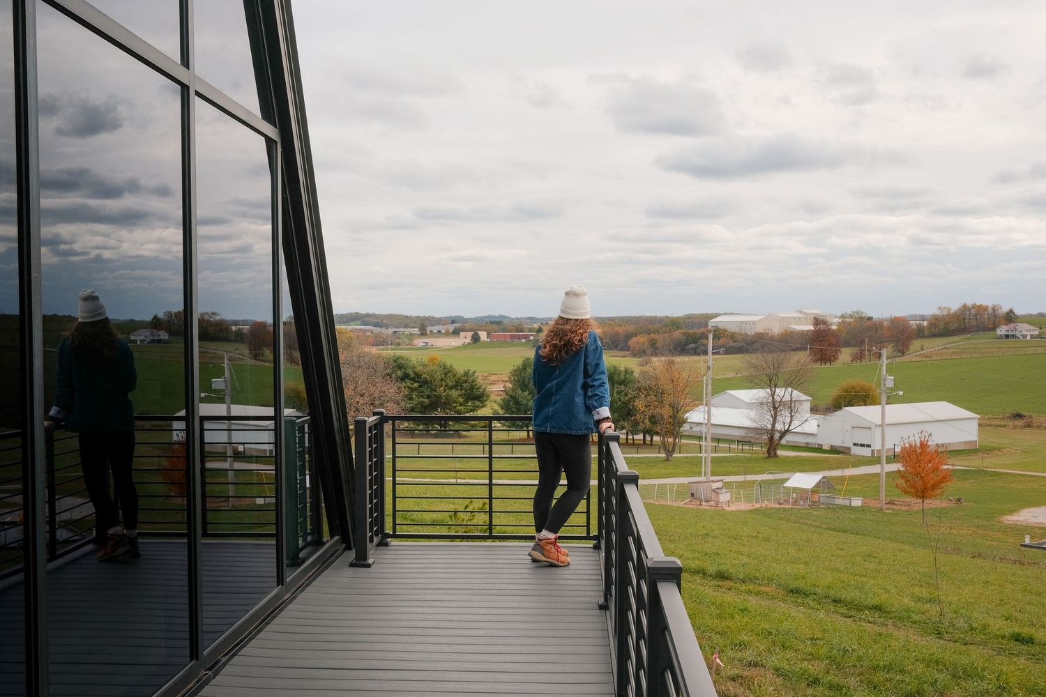 Expansive deck with black railings offering panoramic views of rural countryside.