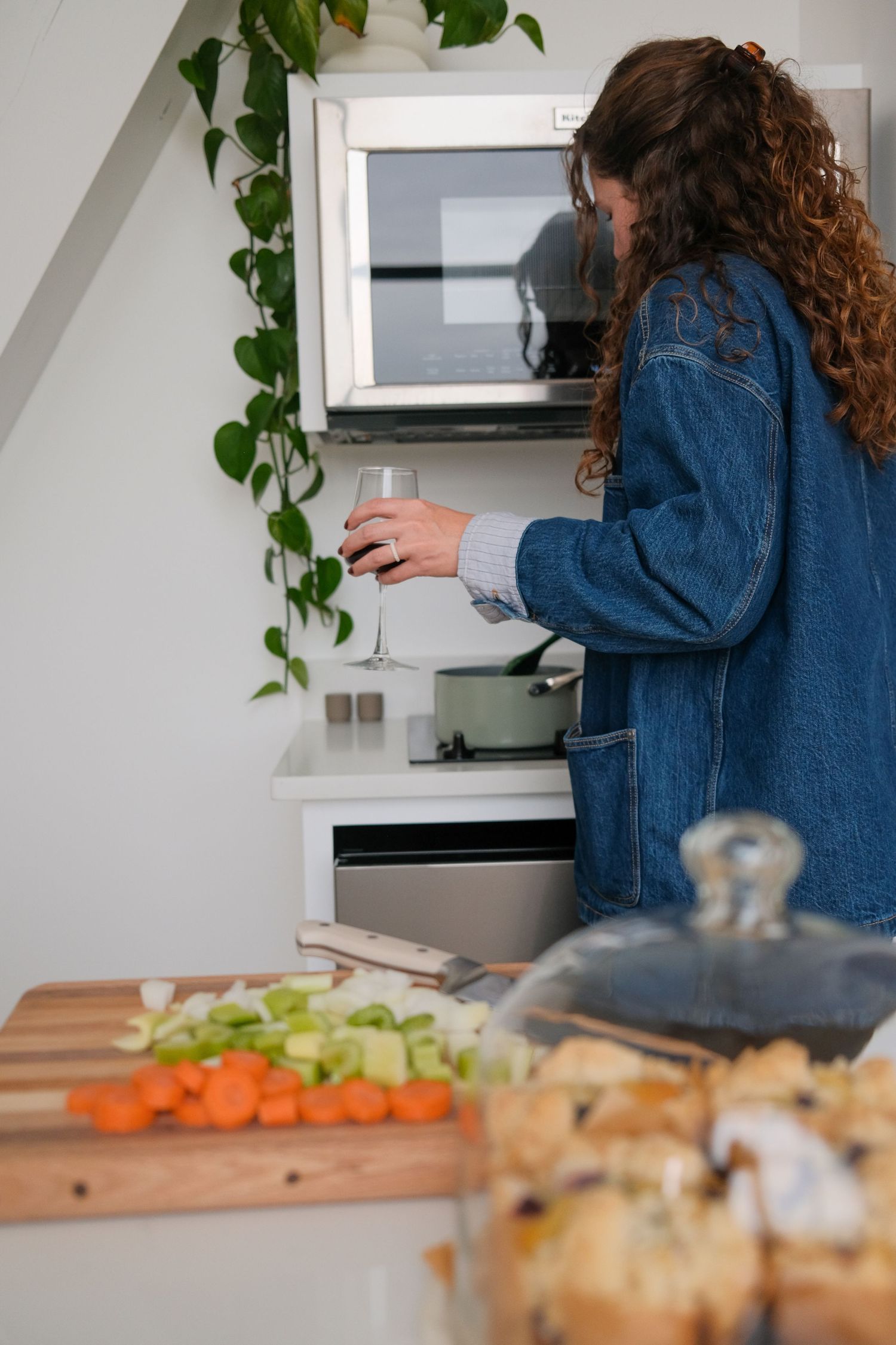 Kitchen scene with fresh ingredients being prepared on a wooden cutting board.