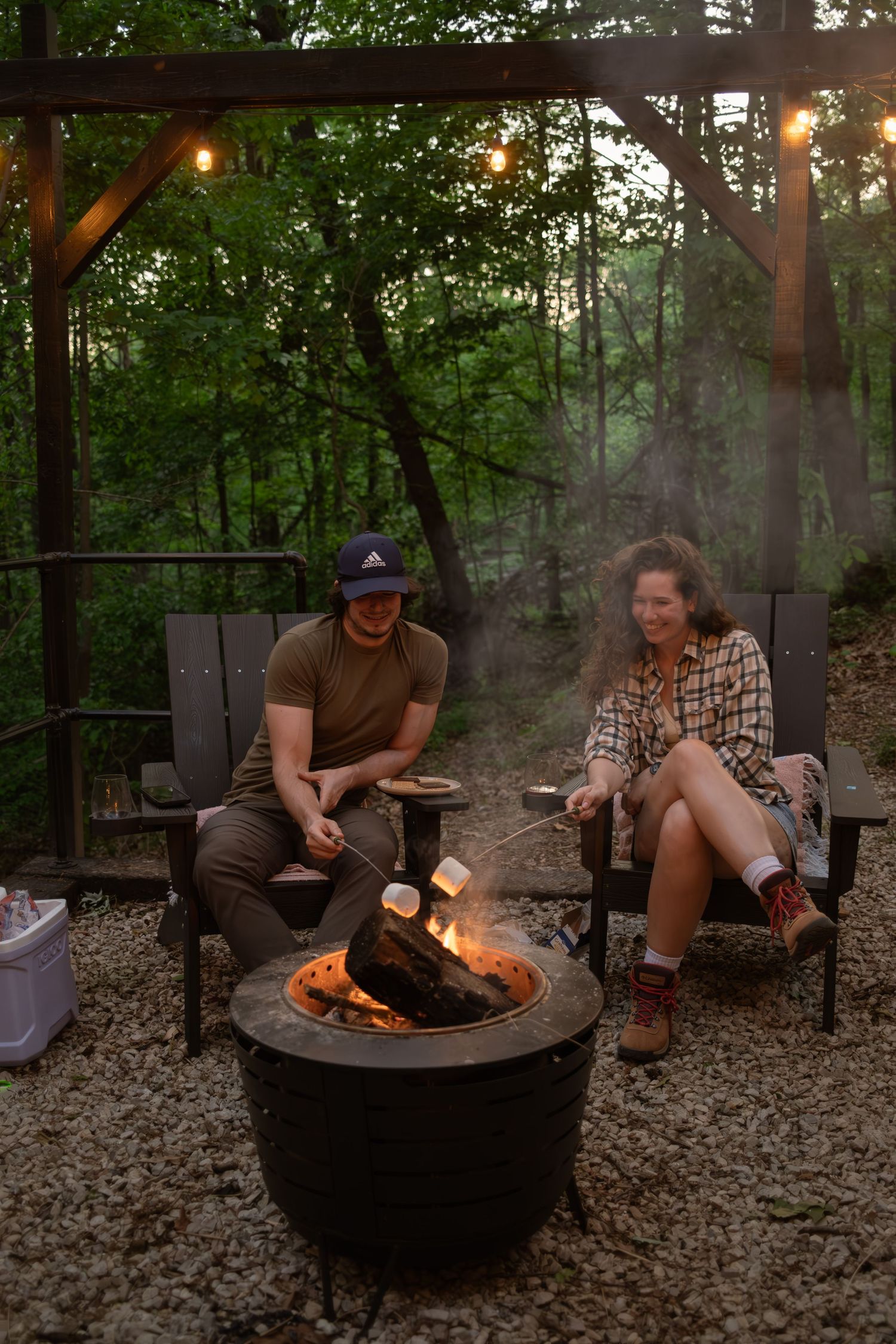 People gathered around a fire pit roasting marshmallows on a rustic outdoor patio.