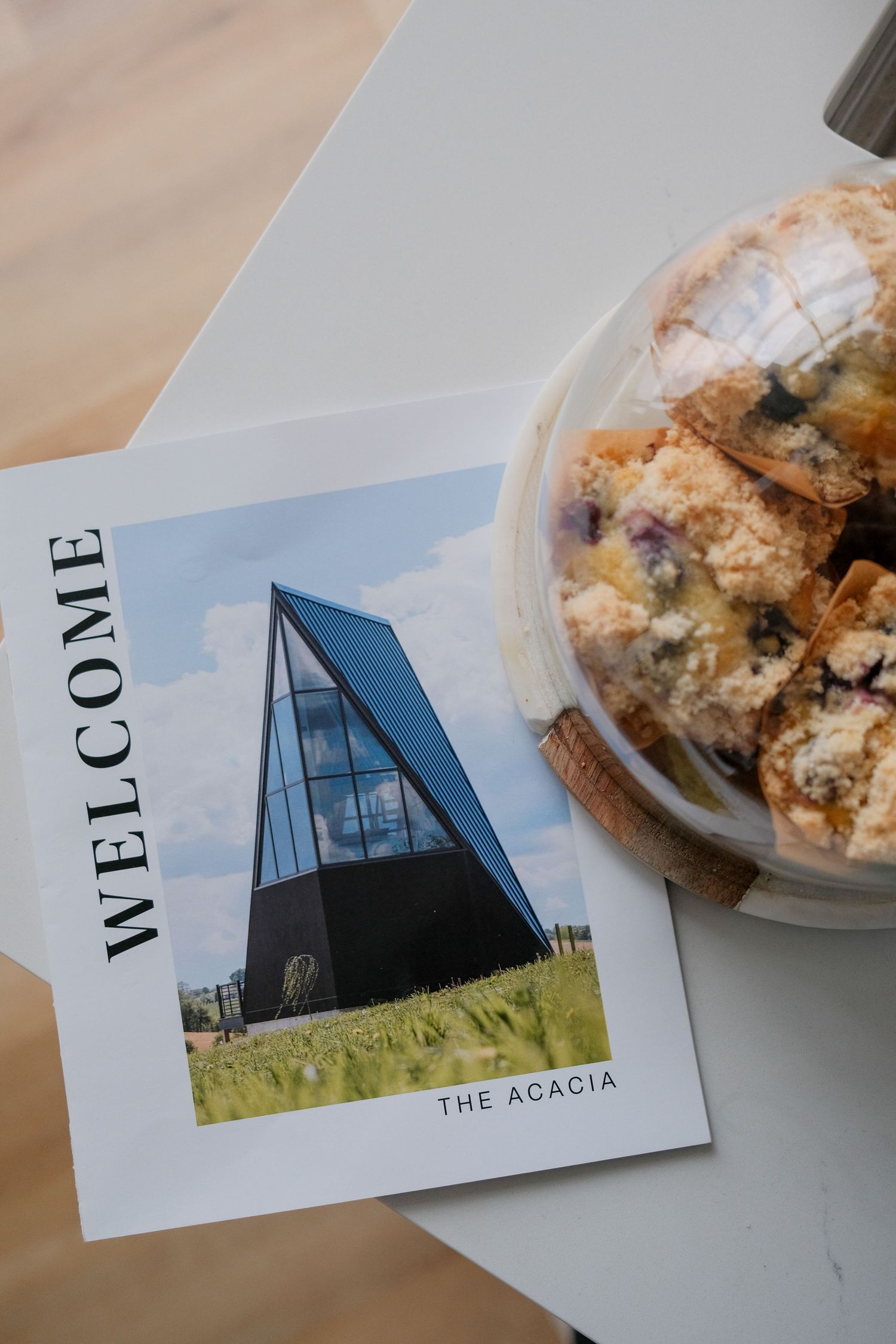 Welcome brochure displaying modern architectural photos and pastries on a table.