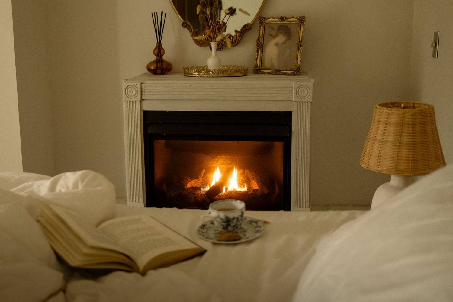 A cozy bedroom interior with a fireplace and soft lighting creating a warm, inviting atmosphere.
