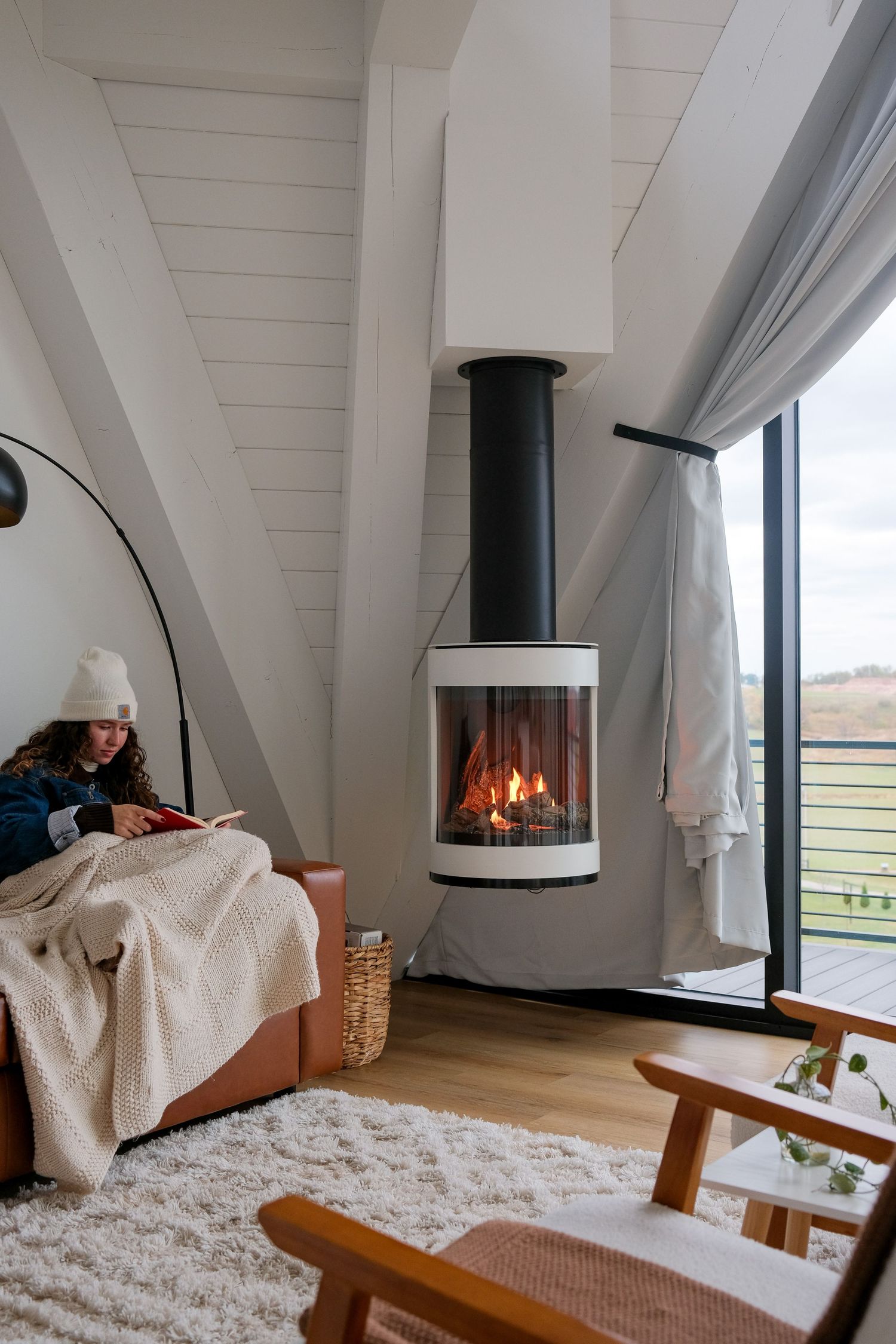 Cozy modern loft interior with white walls, fireplace, and plush area rug creating a warm atmosphere.