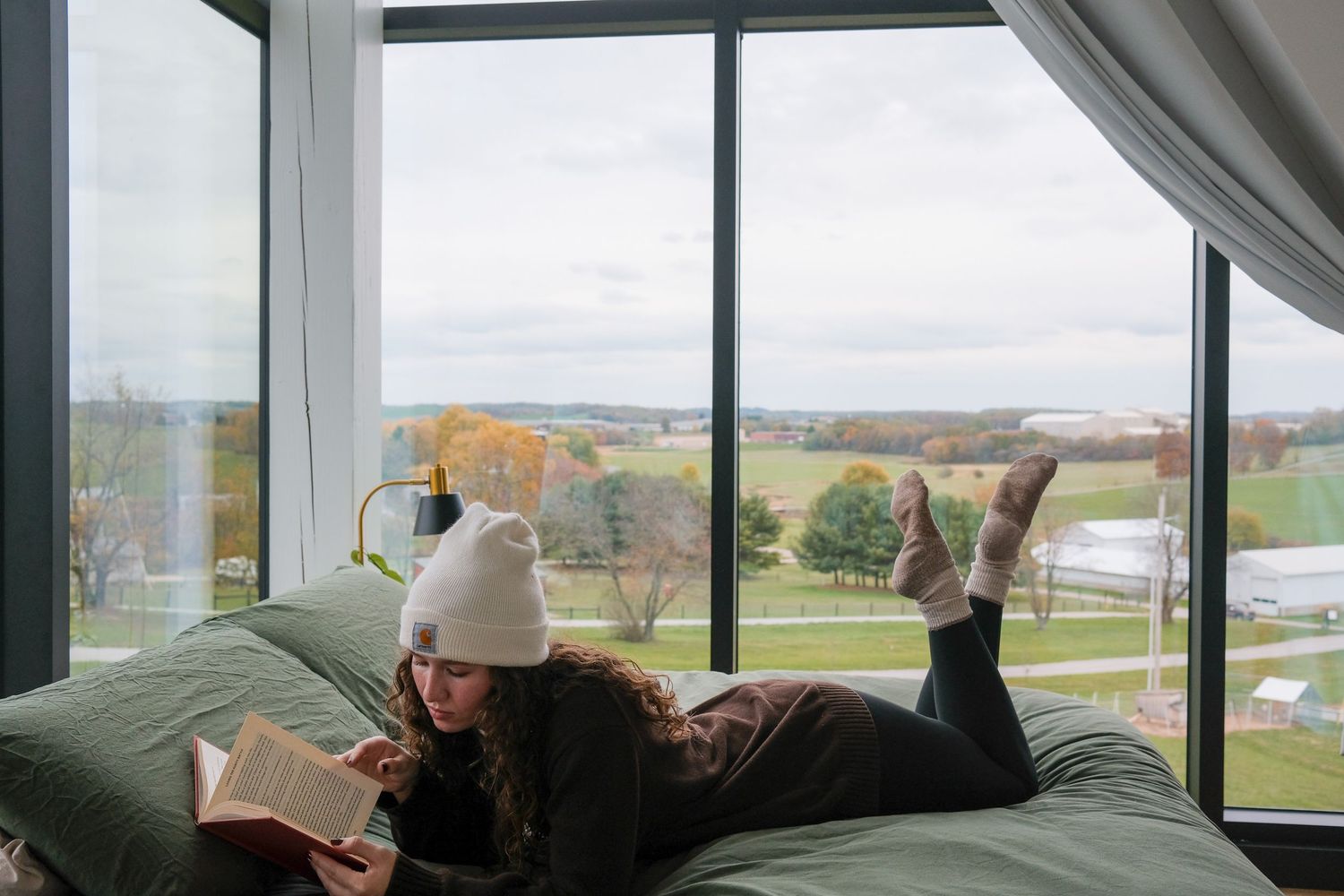 Large windows frame a scenic countryside view in a modern interior space.