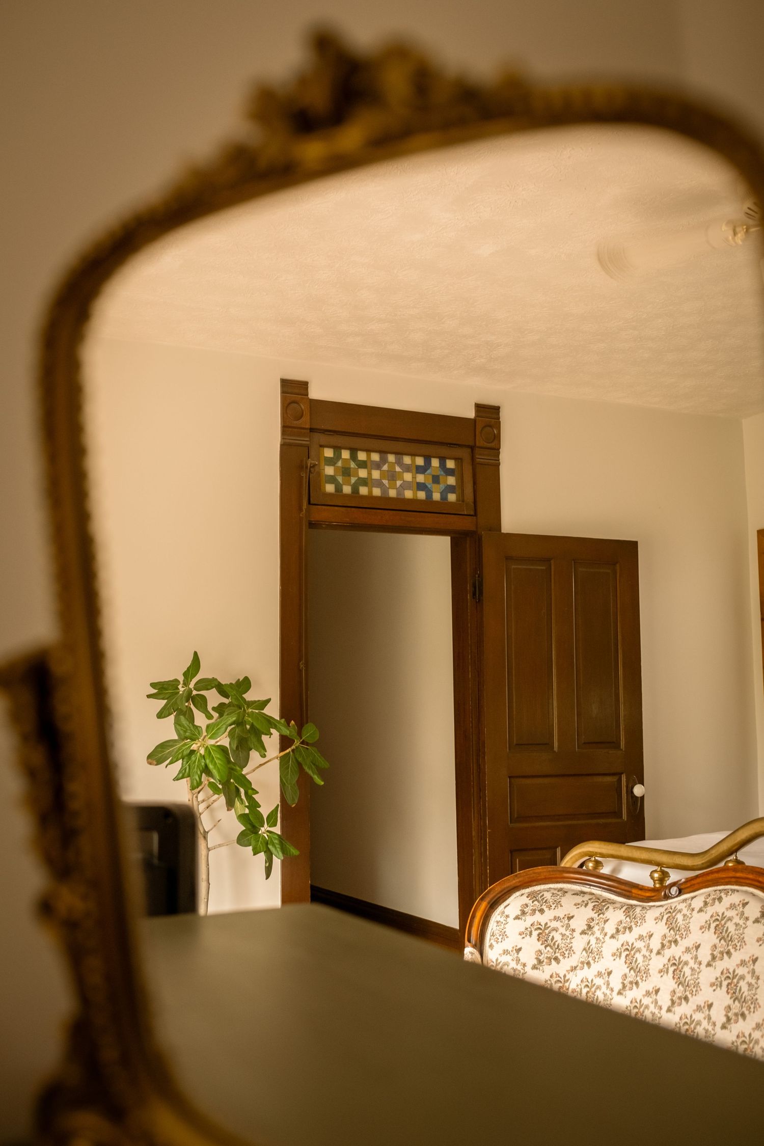 Vintage-style bedroom with dark wooden doors and floral upholstered furniture.