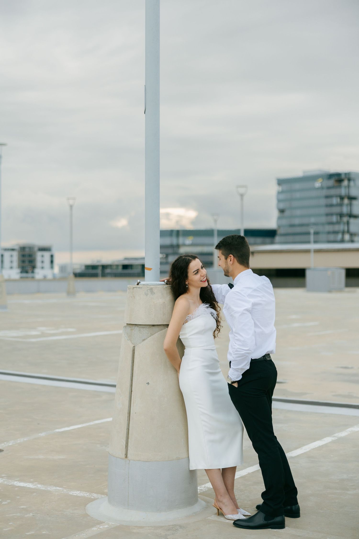 couple posed against a lamp post on the rooftop