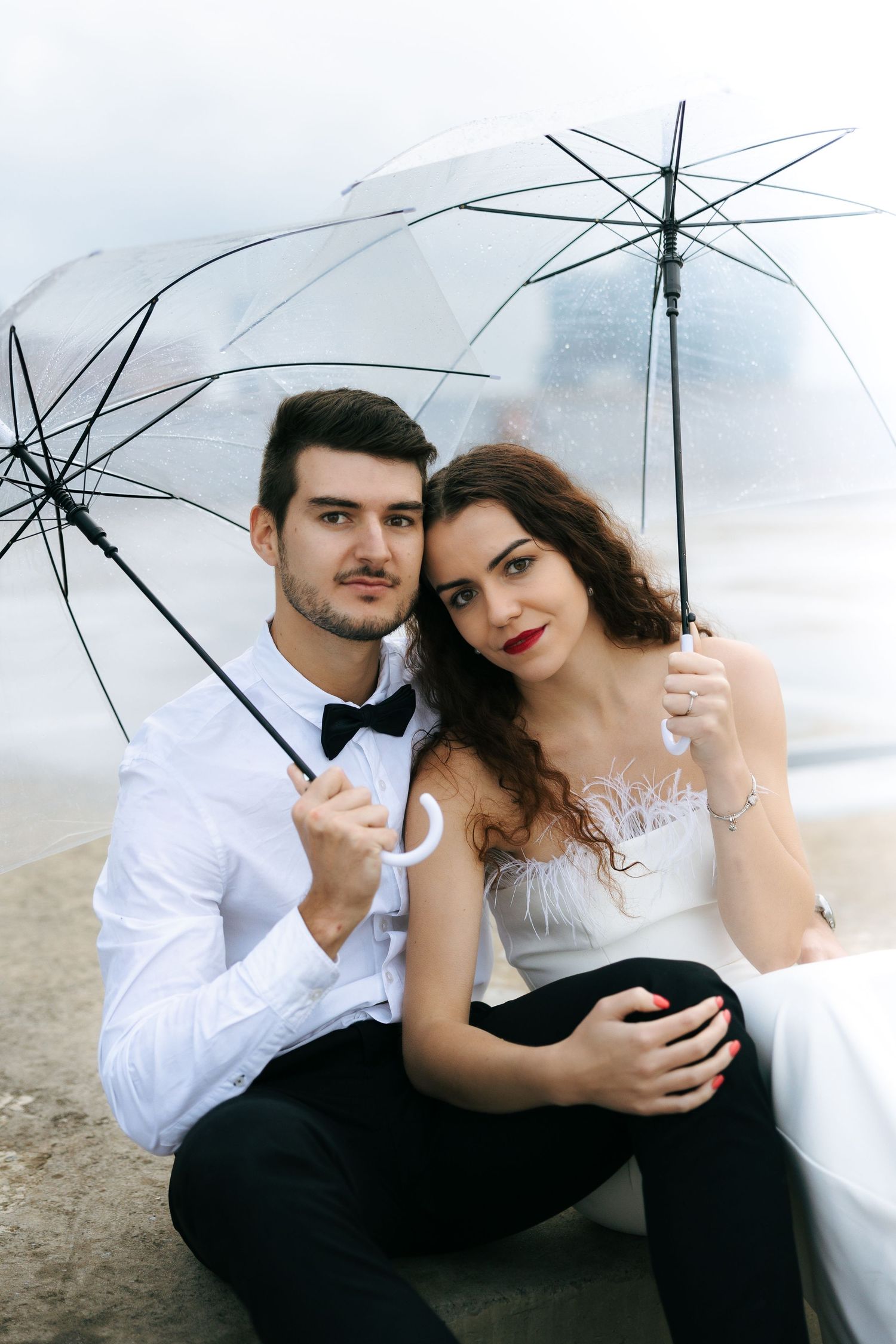 couple posed under umbrellas on a rooftop