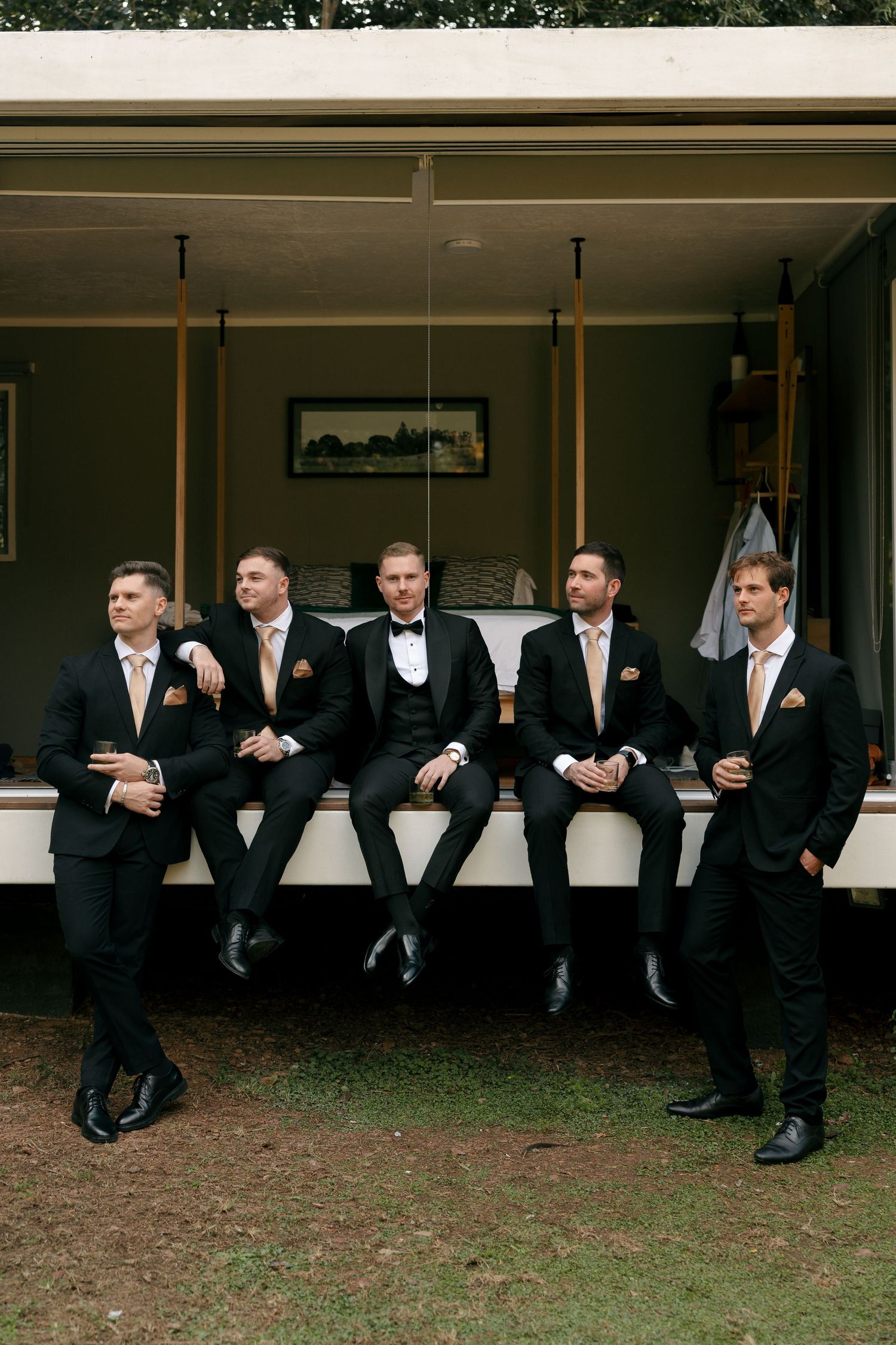 groom and his groomsmen relaxing outside of greenhouse cafe grooms room