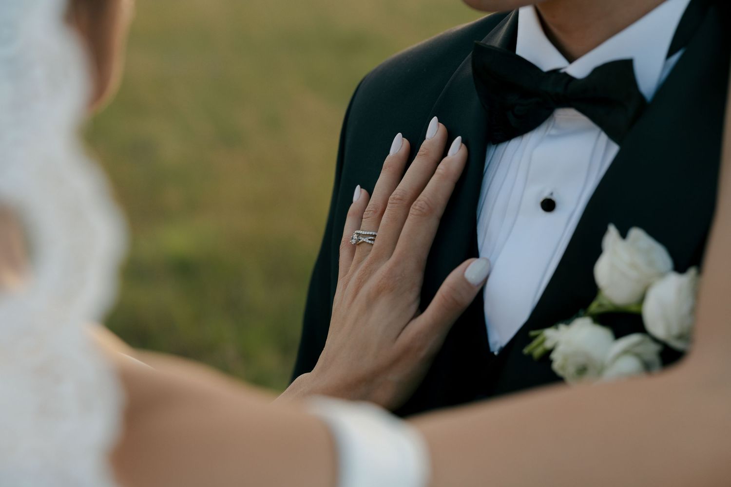 brides hand on grooms chest showing her ring