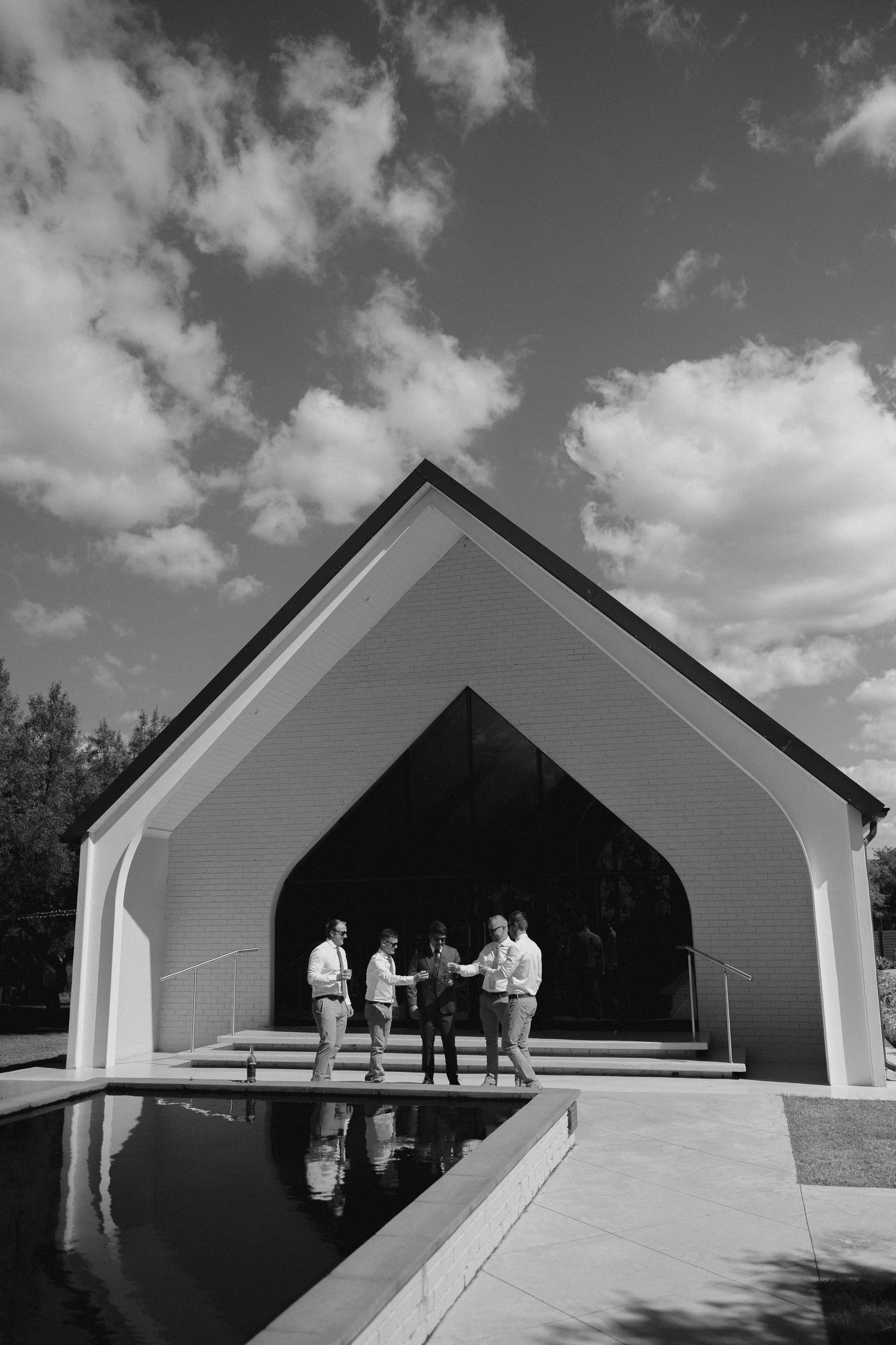 Groom and groomsmen standing outside of a chapel