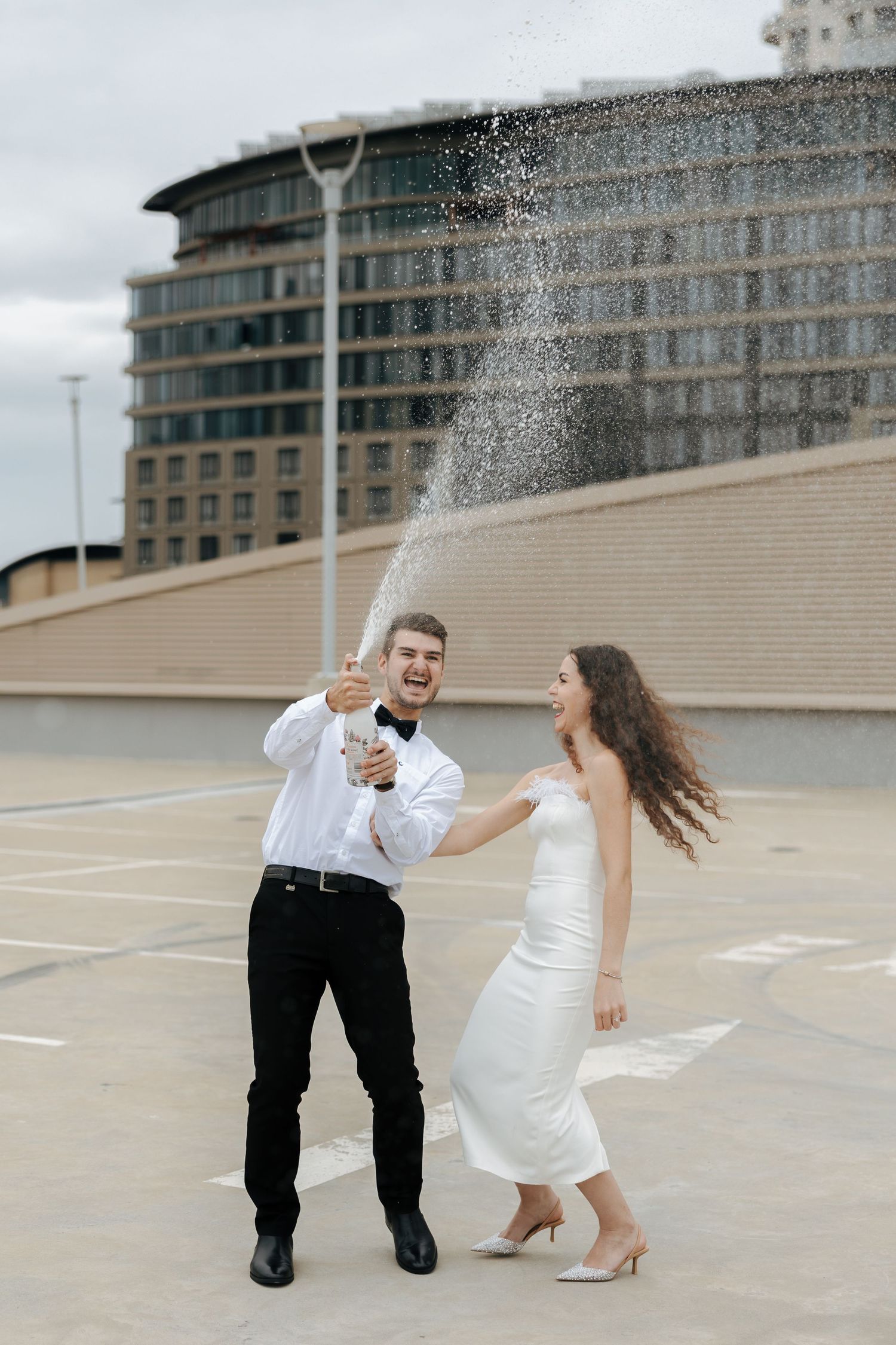 couple on a roof top doing a champagne spray