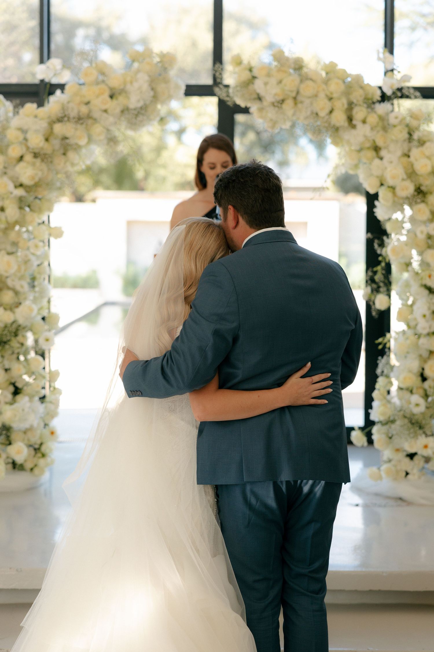 bride and groom hugging in front of the chapel