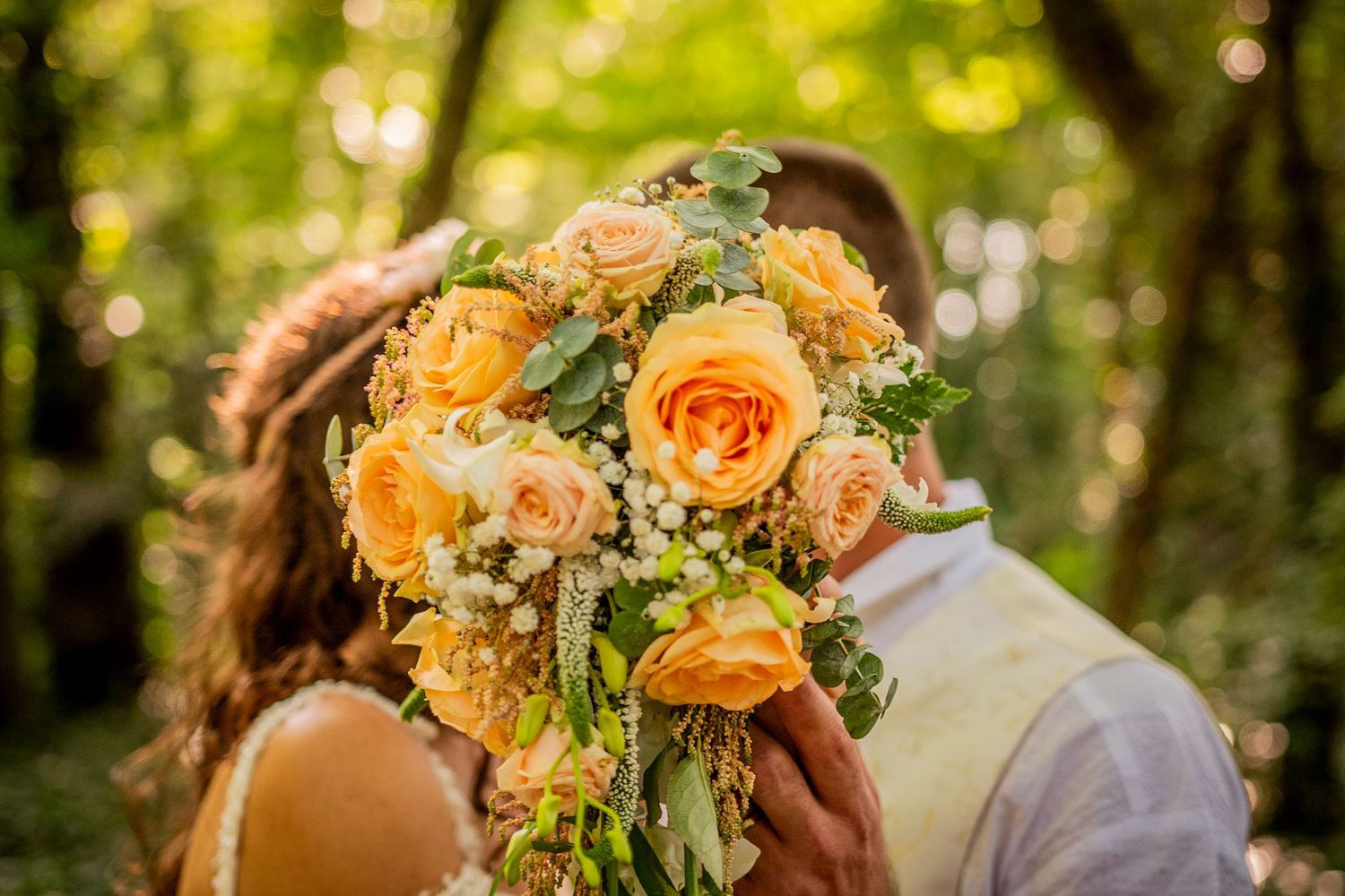 Vibrant orange roses and delicate foliage in a romantic wedding bouquet.