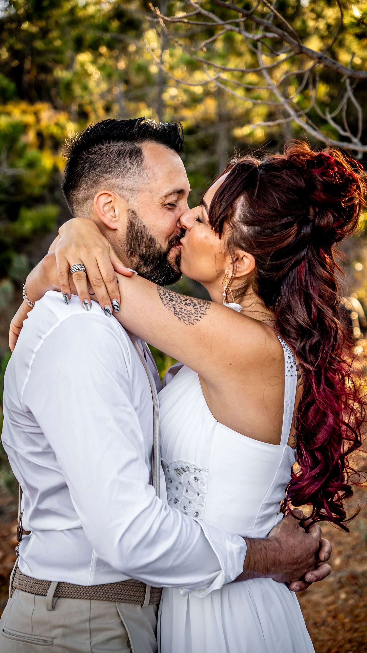 Wedding couple sharing intimate kisses in a golden-lit outdoor setting.