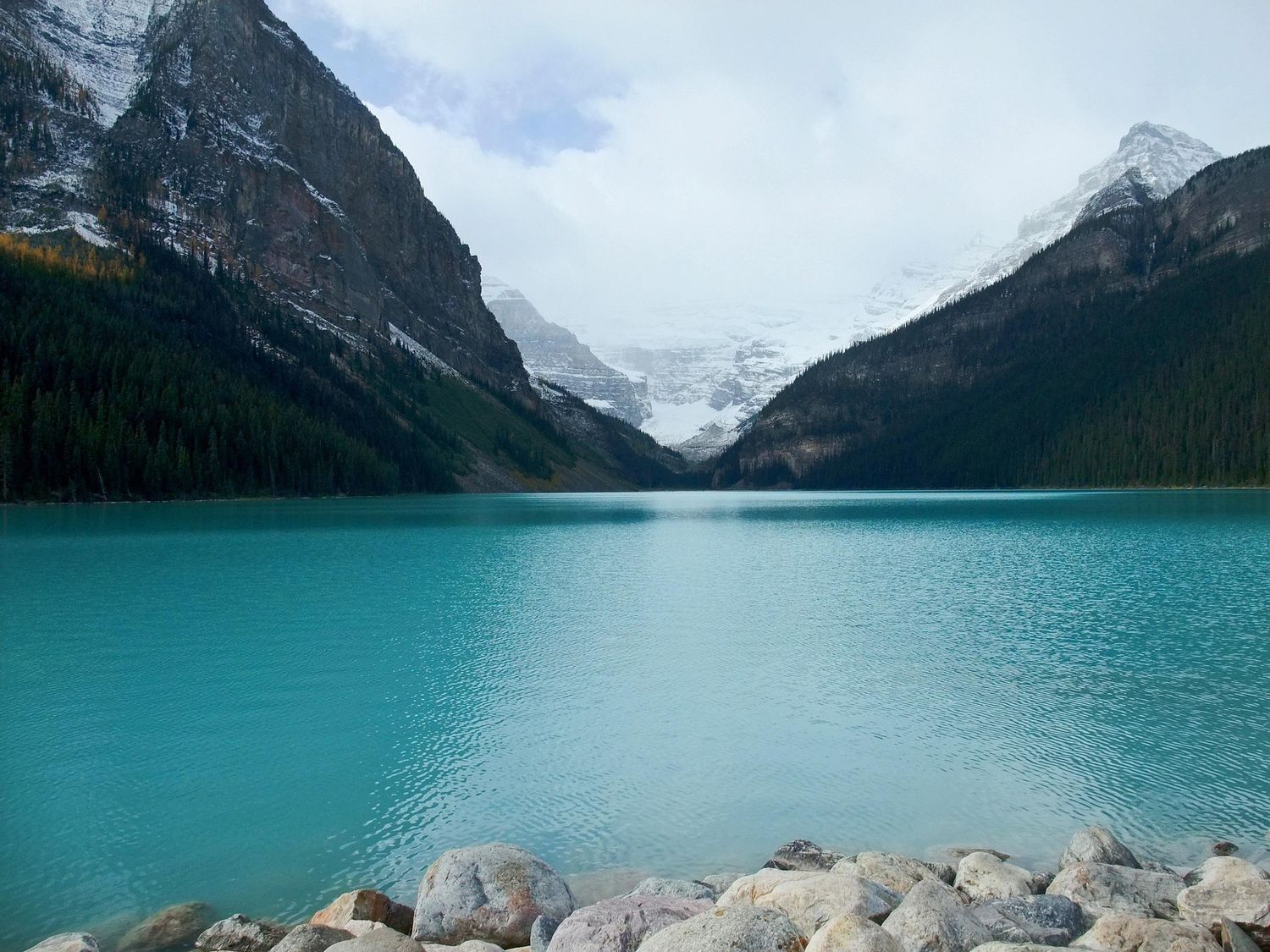 A stunning panoramic view of Lake Louise in Banff National Park with turquoise waters and snow-capped mountains.