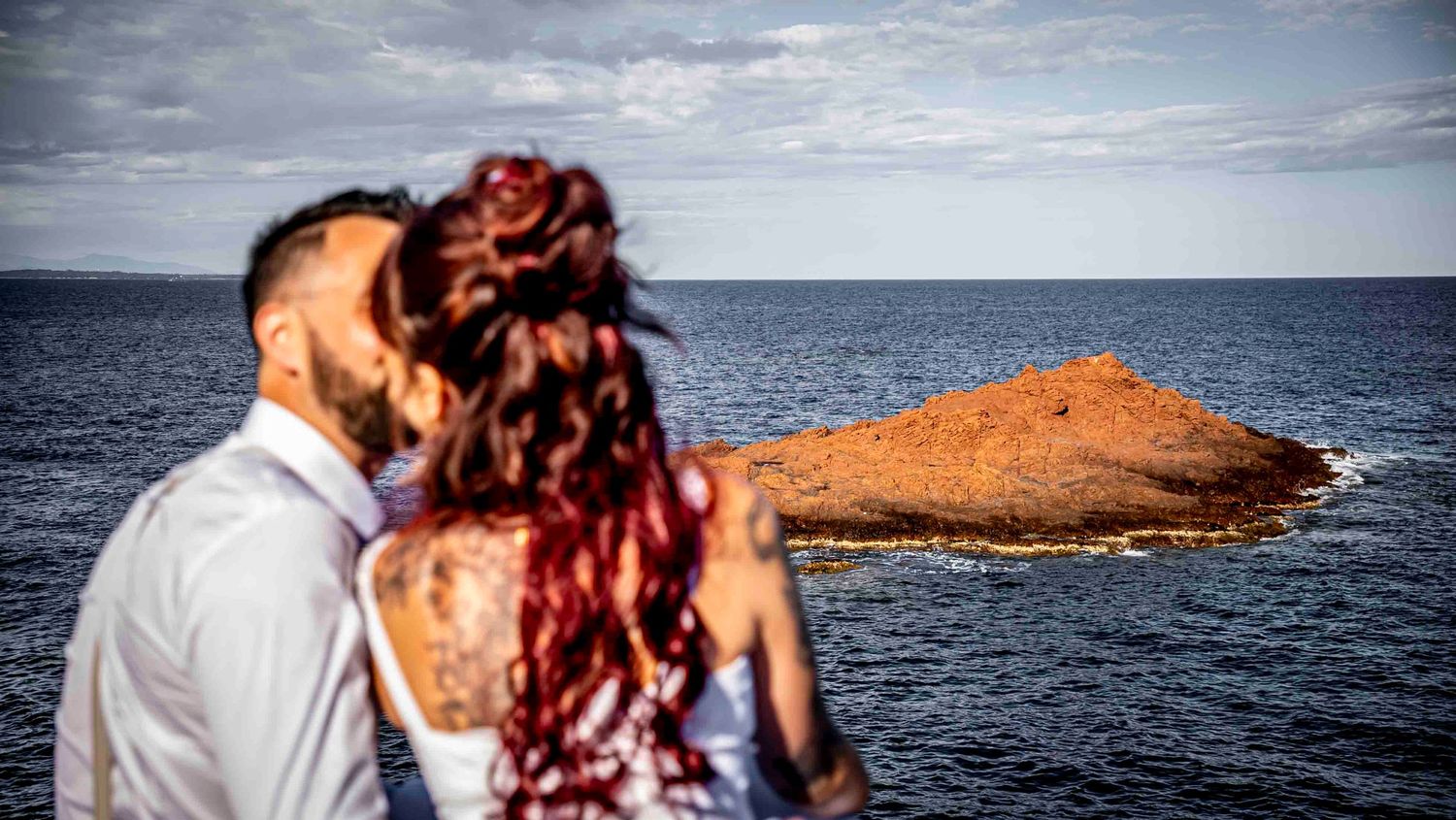Series of romantic panoramic shots of a couple on the seaside with a dramatic cloudy sky and mountain backdrop.