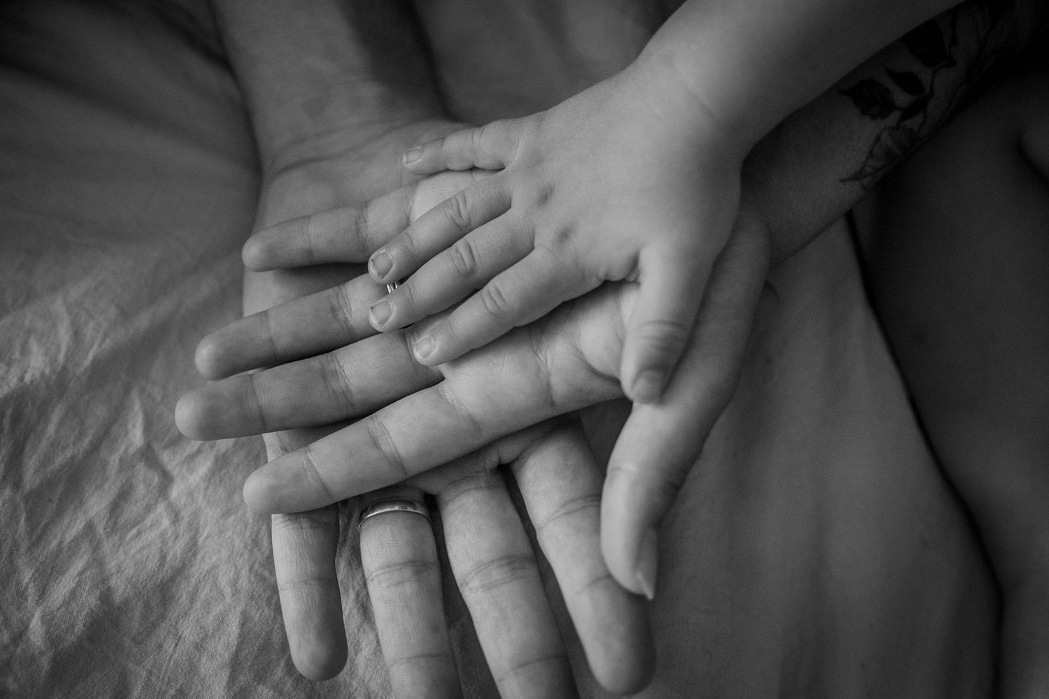 Close-up artistic photo of hands touching gently against white fabric.