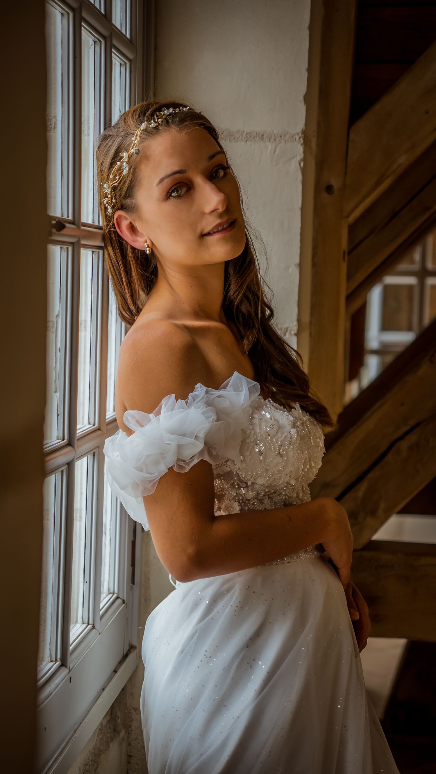 Artistic bridal portrait sequence near a bright window in vintage setting.