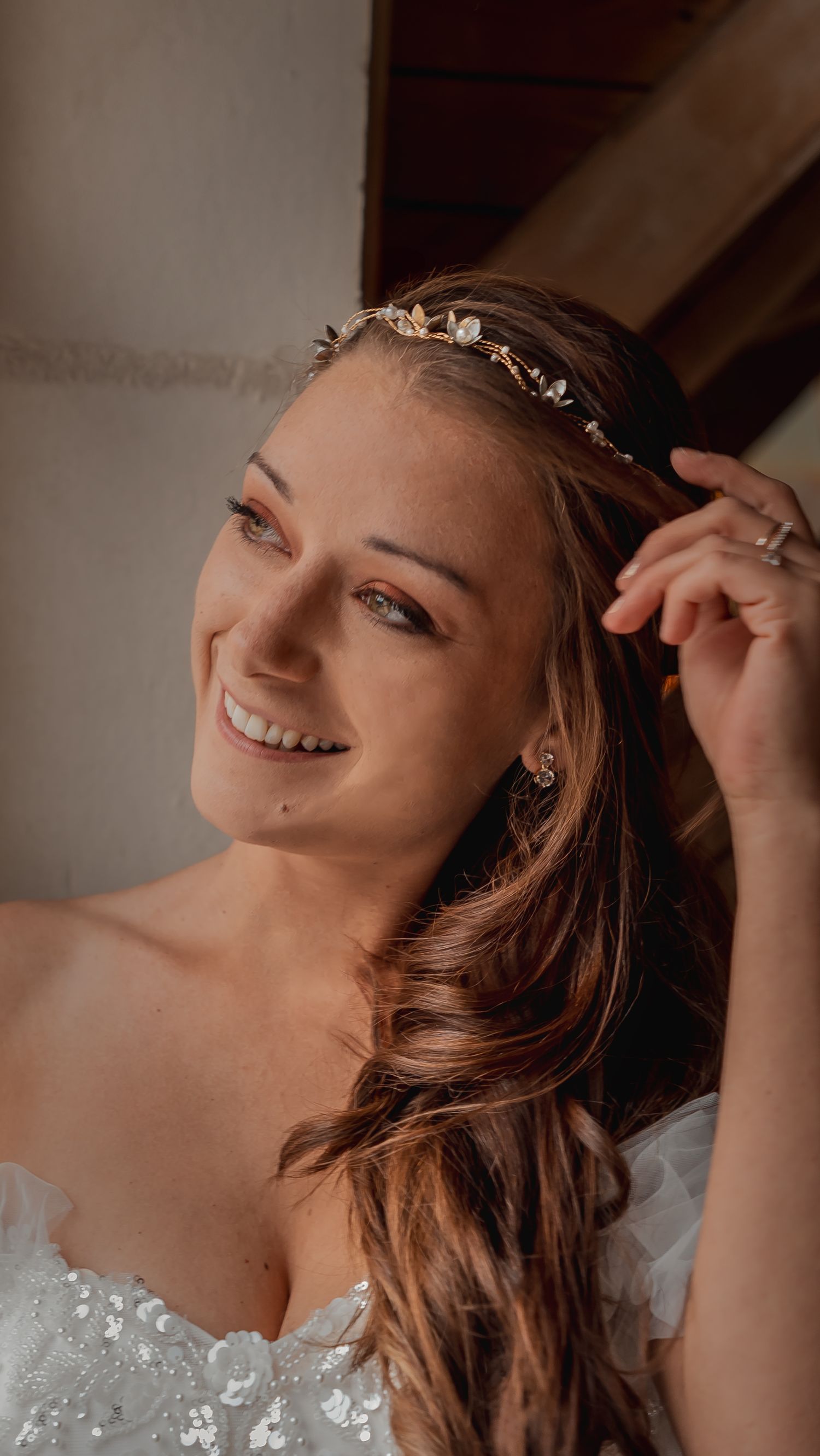 Close-up artistic bridal portrait showing delicate hair accessories and lace details.