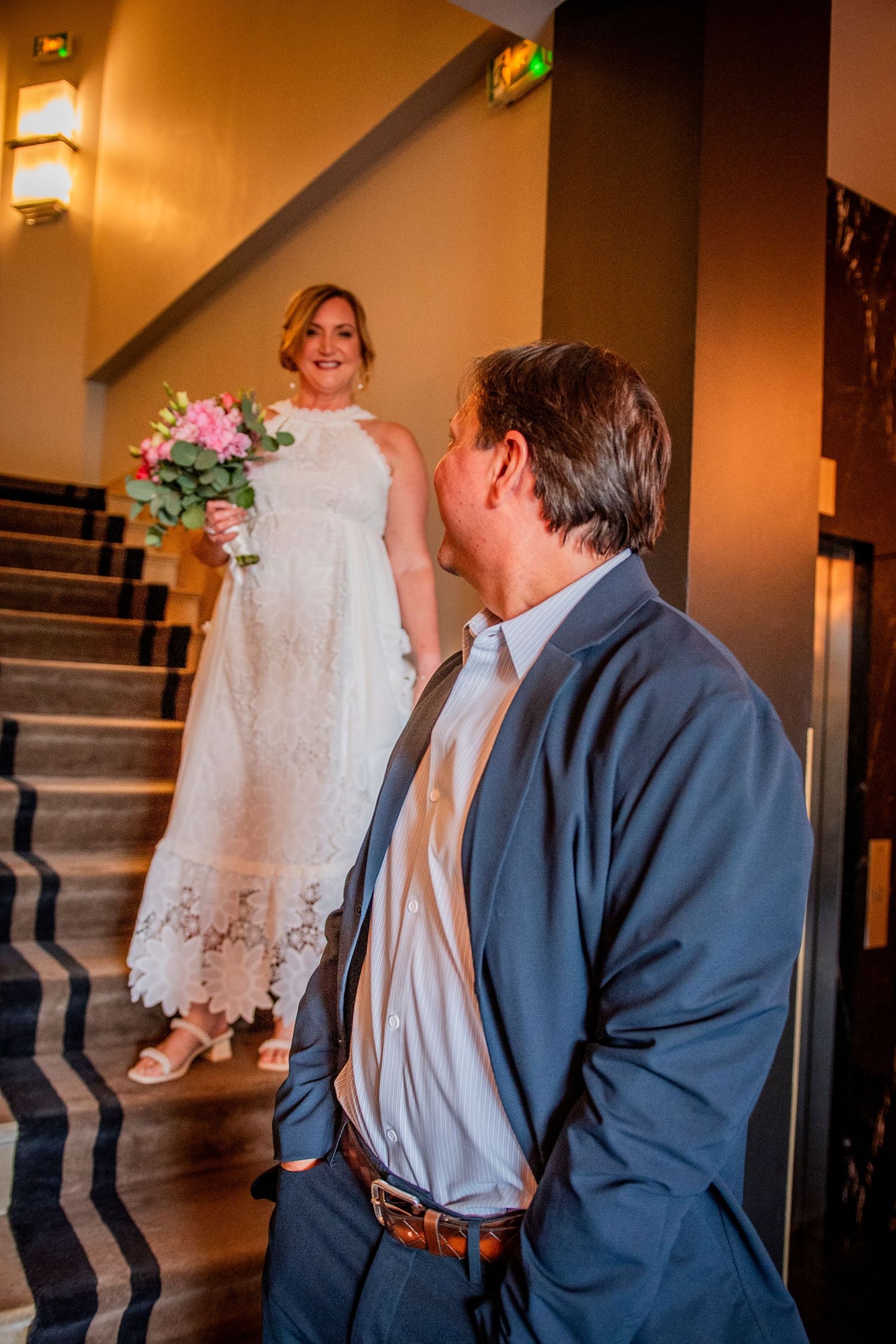 Wedding couple sharing a tender moment on an interior staircase.