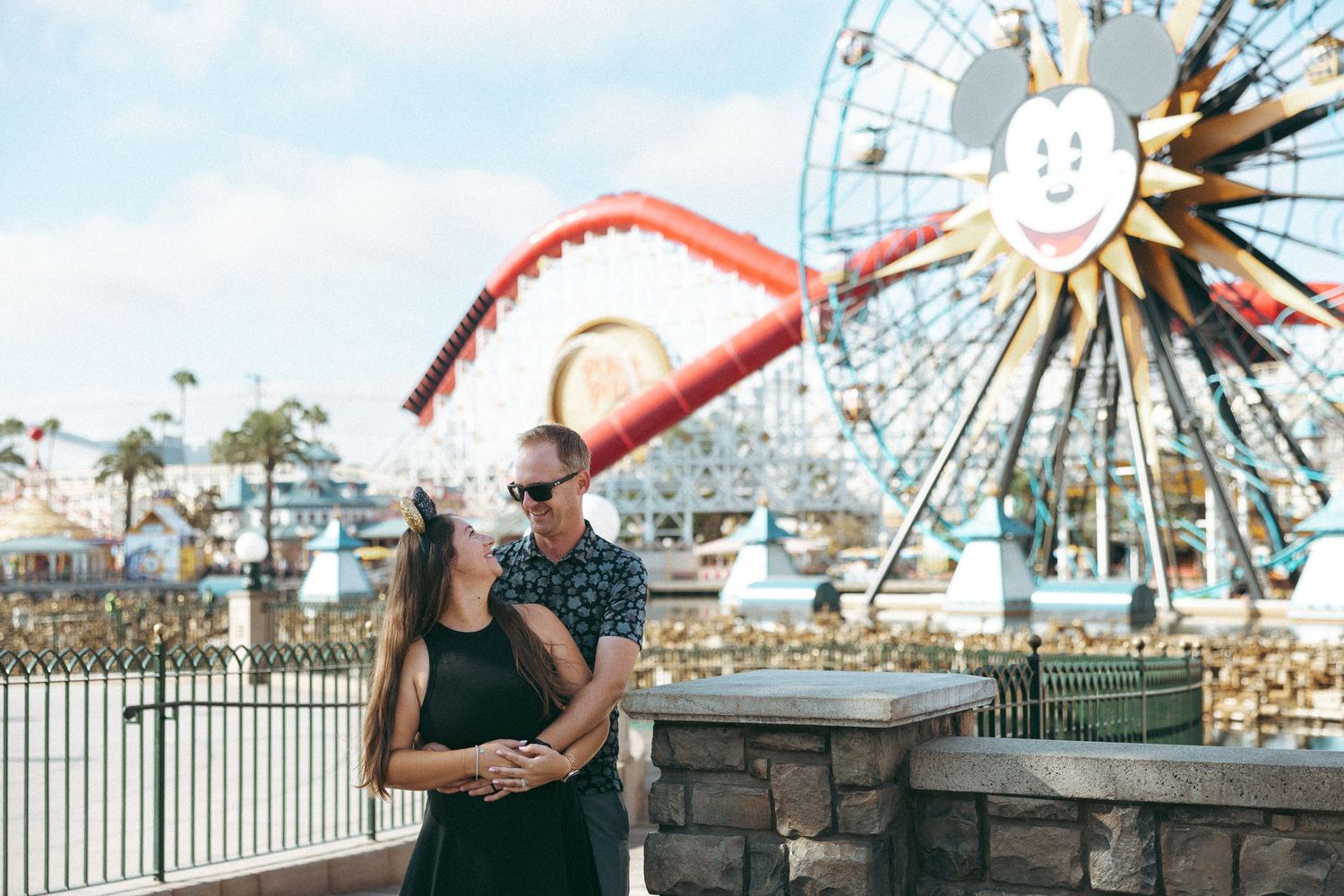 Romantic couple embracing near Mickey's Fun Wheel Ferris wheel at Disney California Adventure.