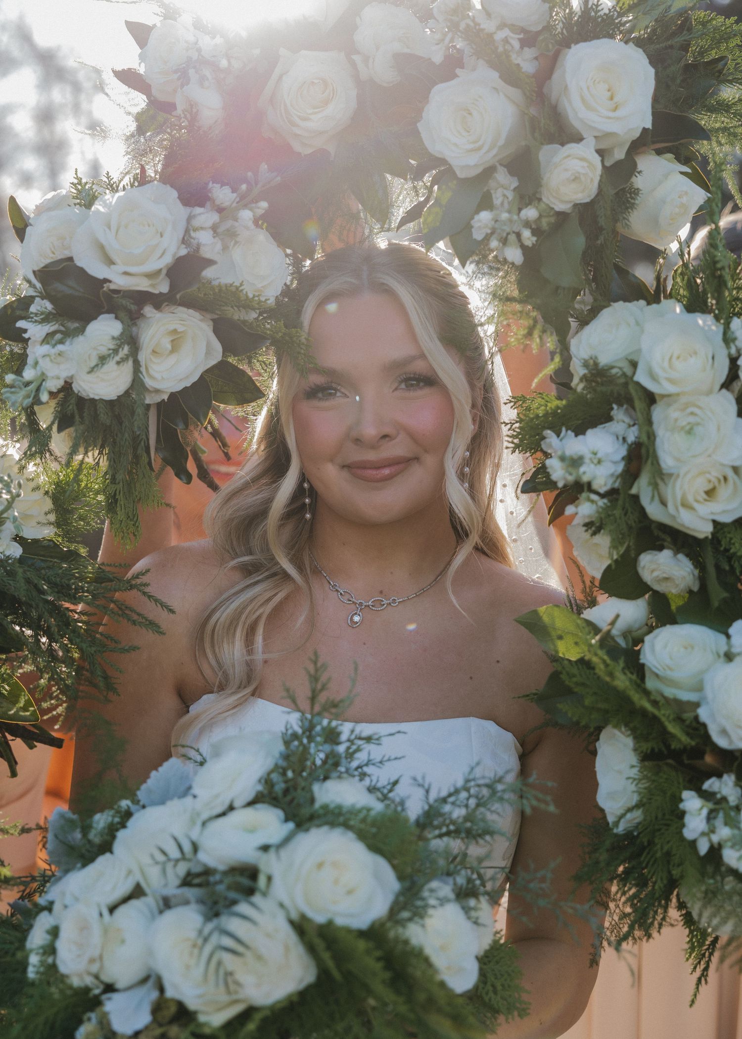 A bridal portrait series featuring white roses and greenery floral arrangements in natural outdoor lighting.