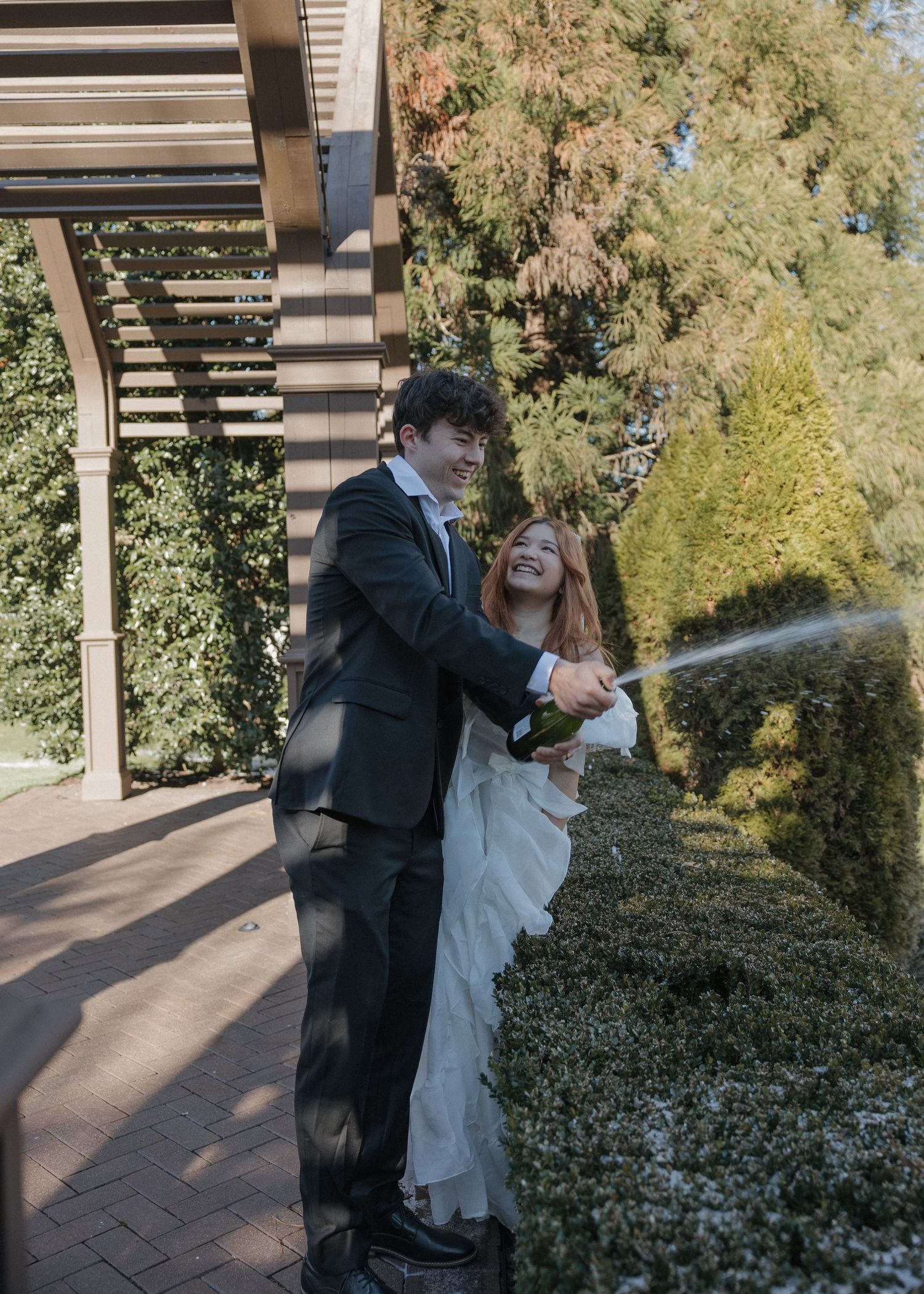 A series of candid moments showing a couple playfully interacting outdoors under a pergola with greenery.