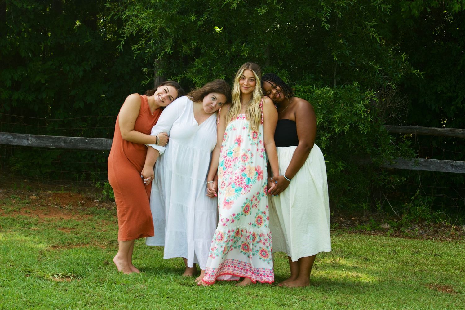 Friends sitting together on grass during outdoor gathering.