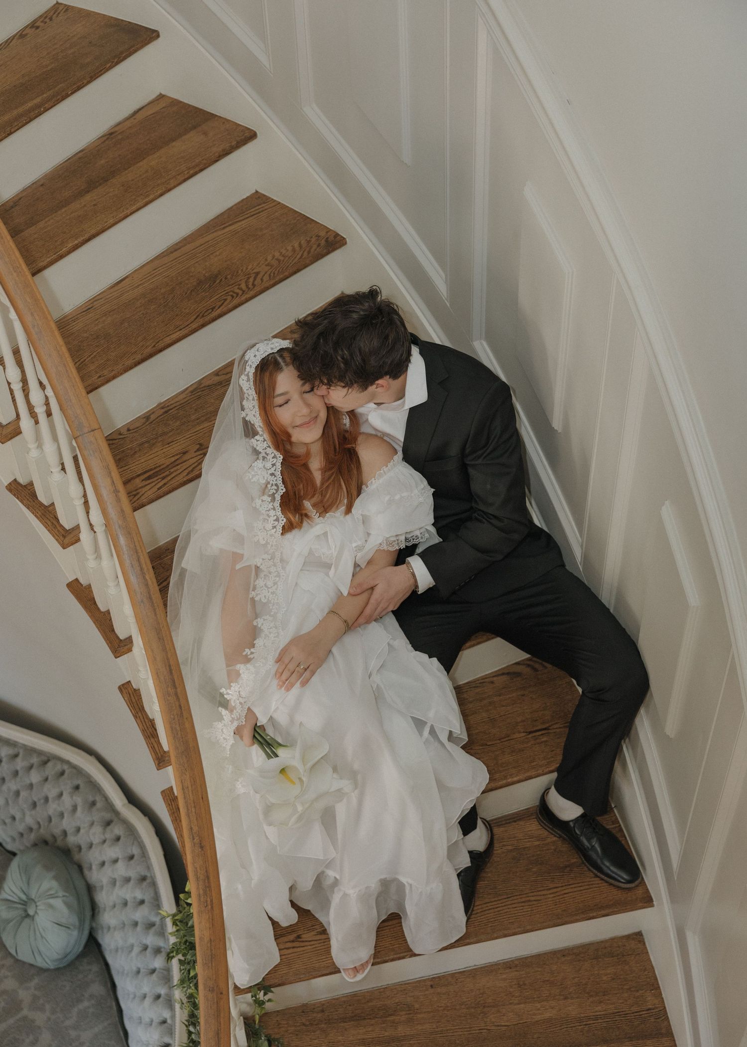 A romantic wedding couple descends a wooden staircase in a series of candid moments captured in sequence.
