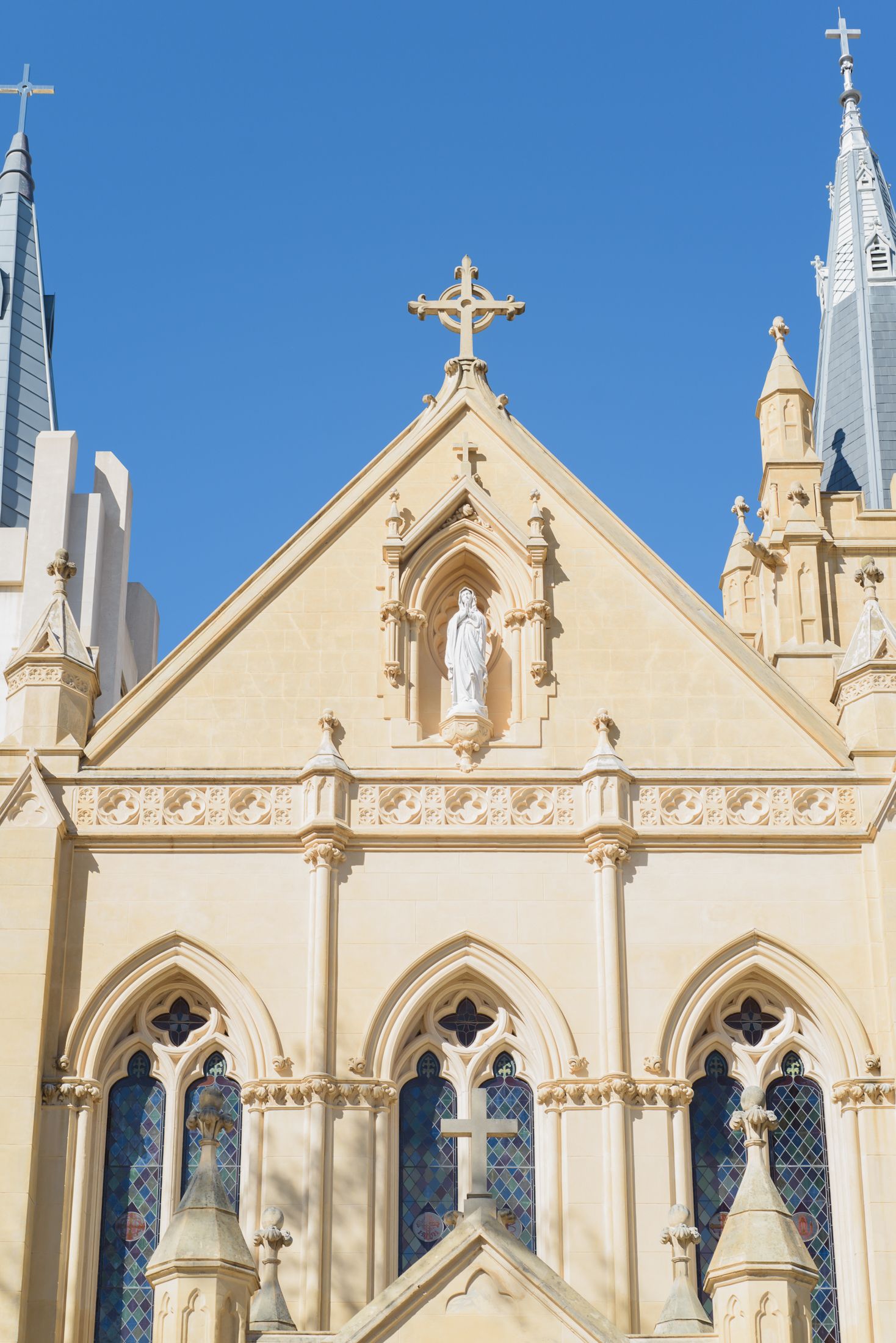 Gothic church spires and ornate architectural details against a bright blue sky.