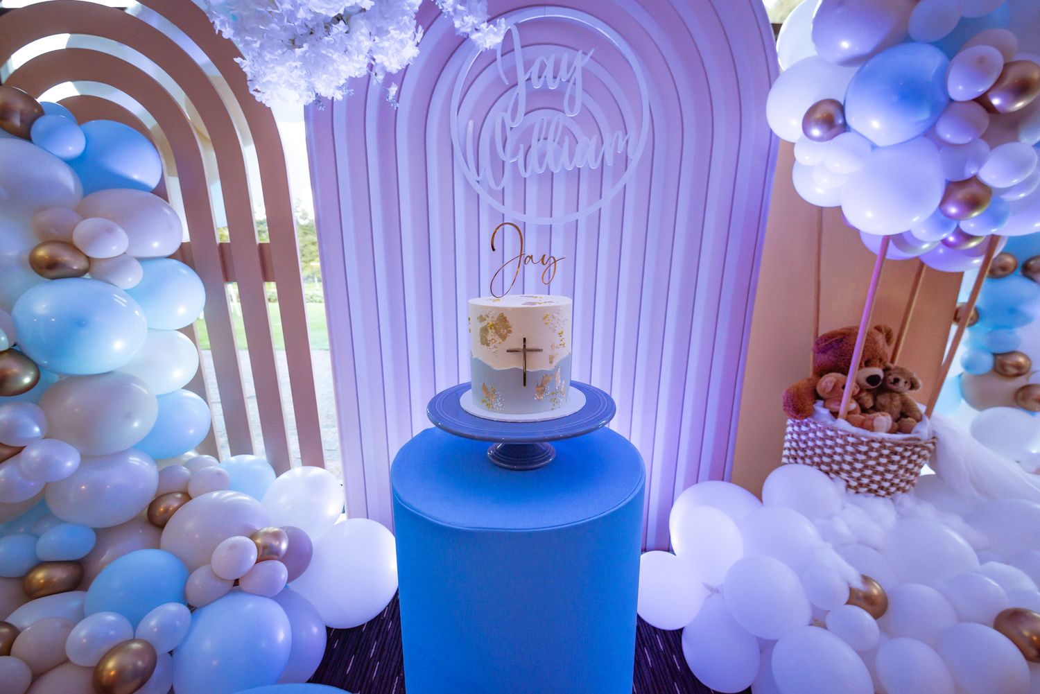 Blue and white balloon arch decorations with elegant party lighting.