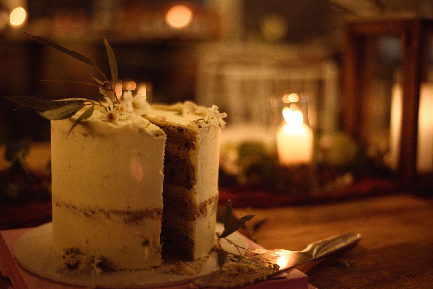Wedding cake display with soft candlelight creating a romantic ambiance.
