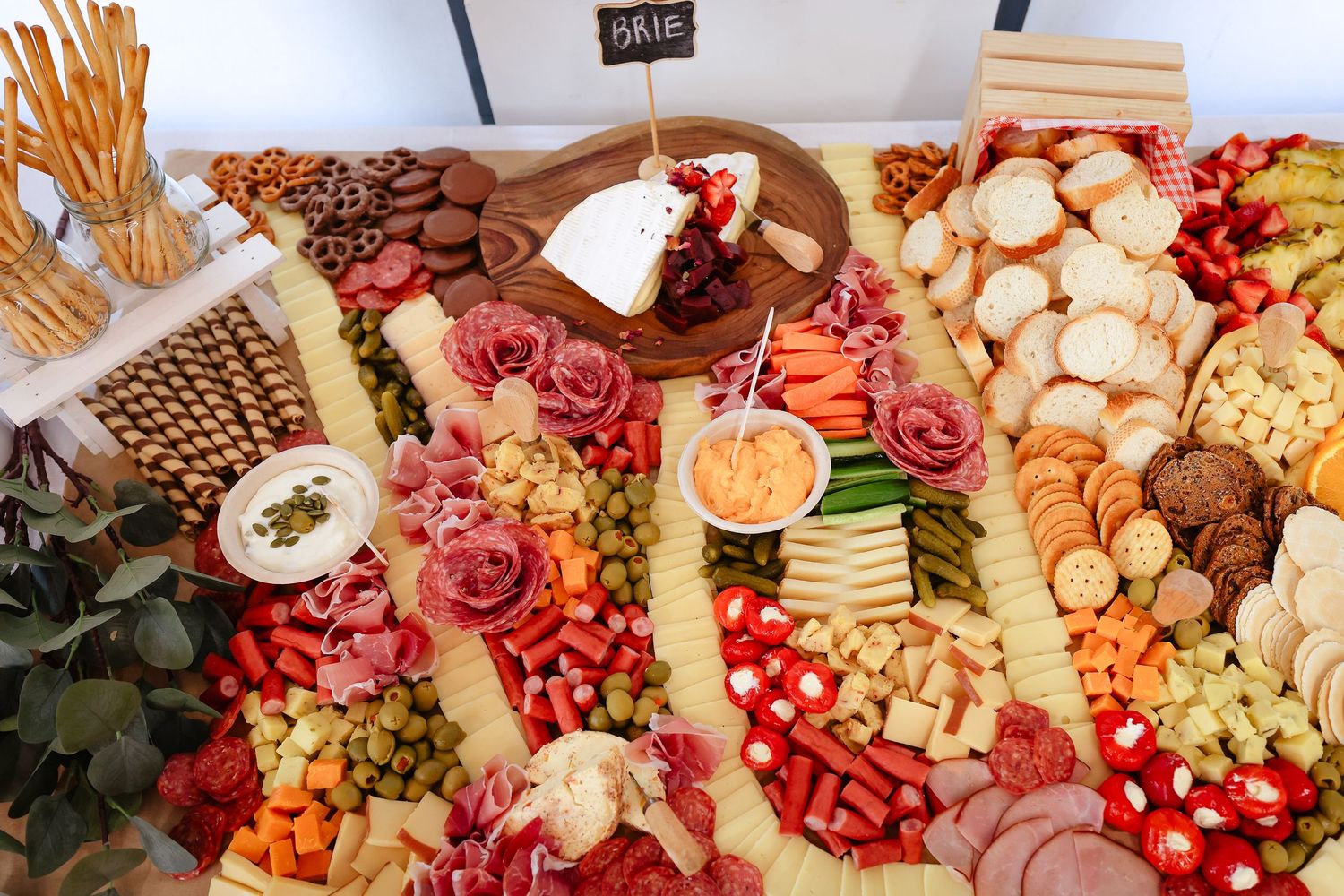 Lavish charcuterie board spread with meats, cheeses, fruits and crackers.