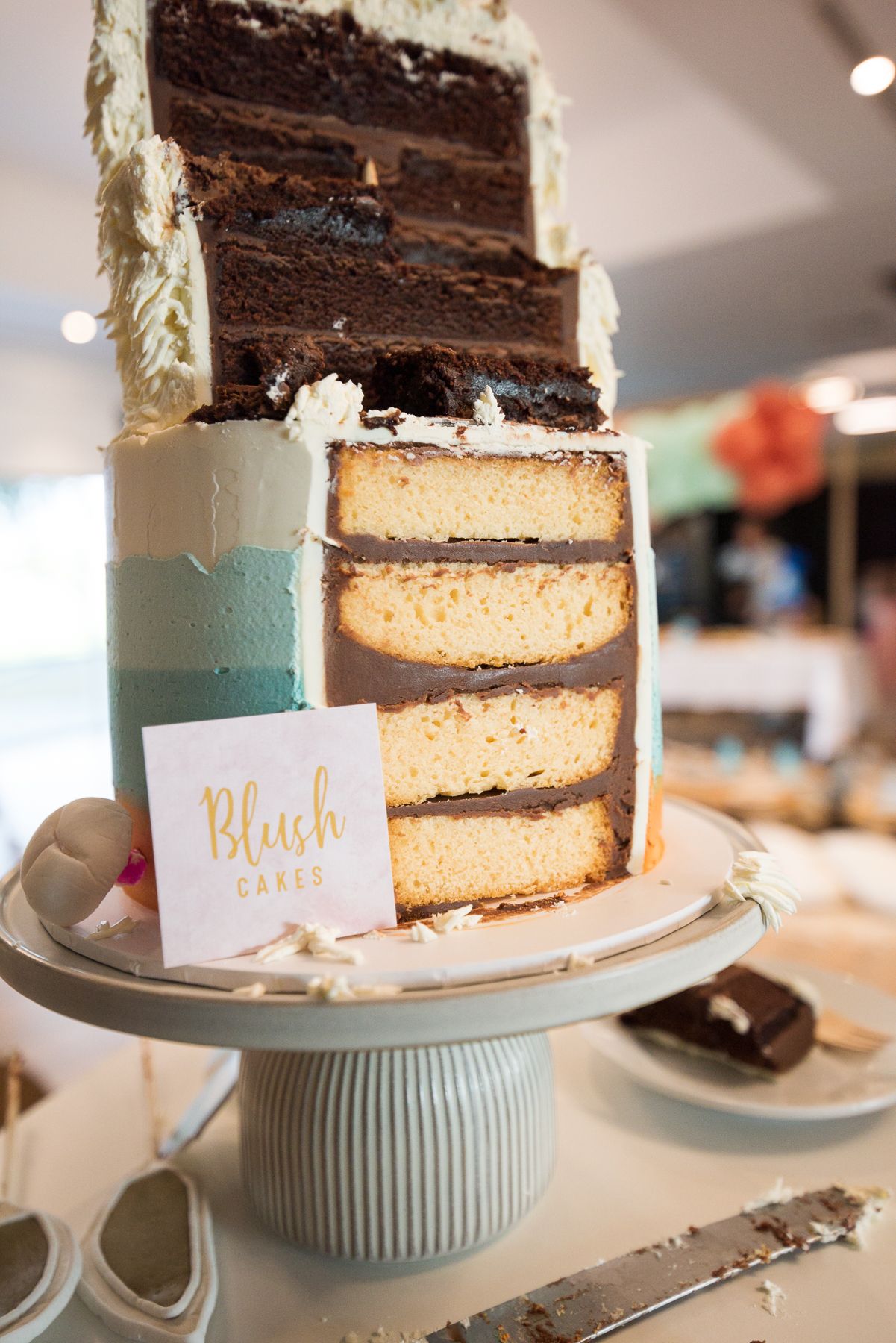 Layered chocolate and vanilla cake displayed on a blue cake stand.