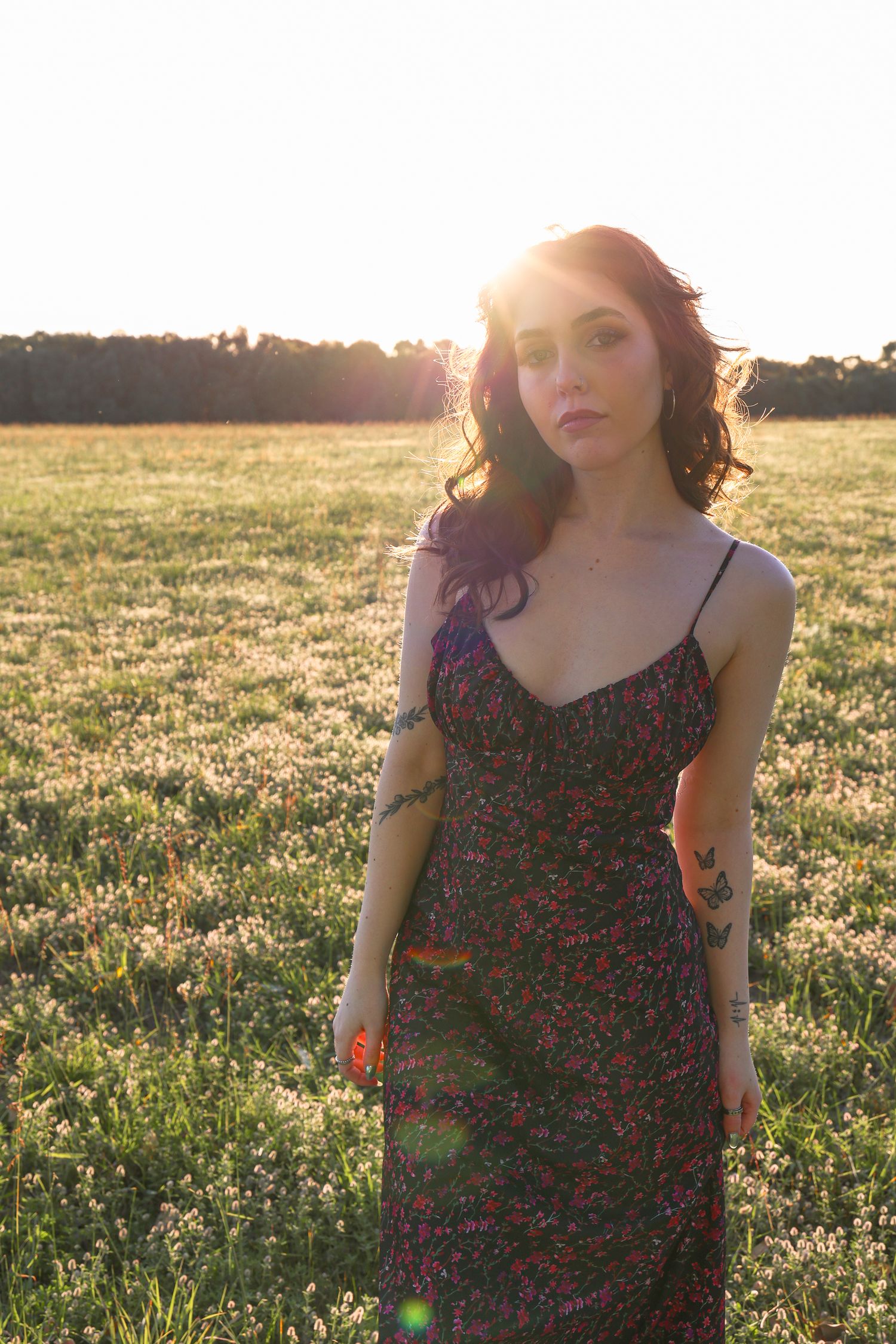 Floral dress photographed in a sunlit field at golden hour.
