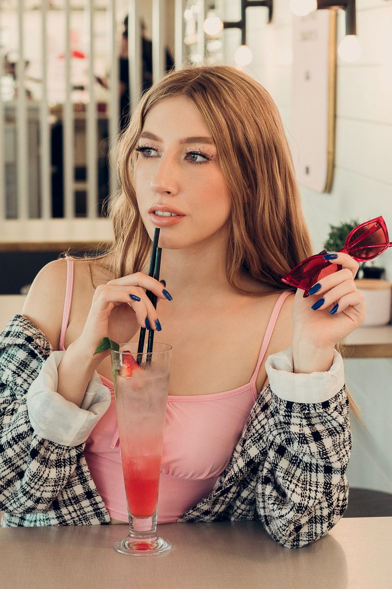 Lifestyle photo series of someone enjoying a pink cocktail at a cafe.