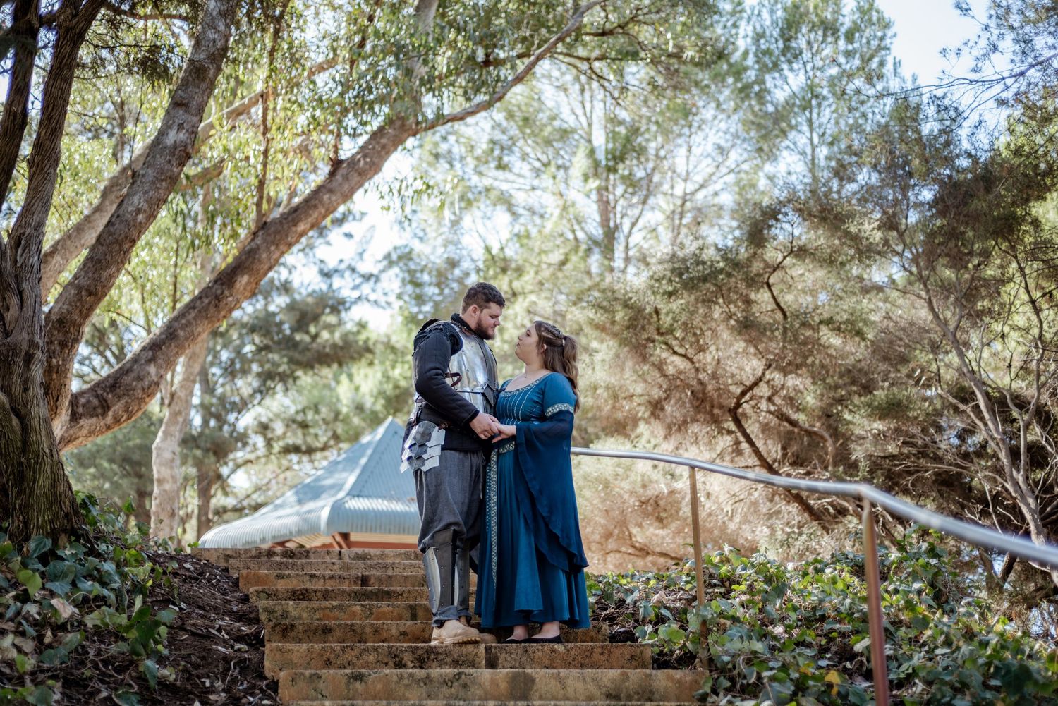 Wedding couple sharing intimate moments among trees in a natural outdoor setting.