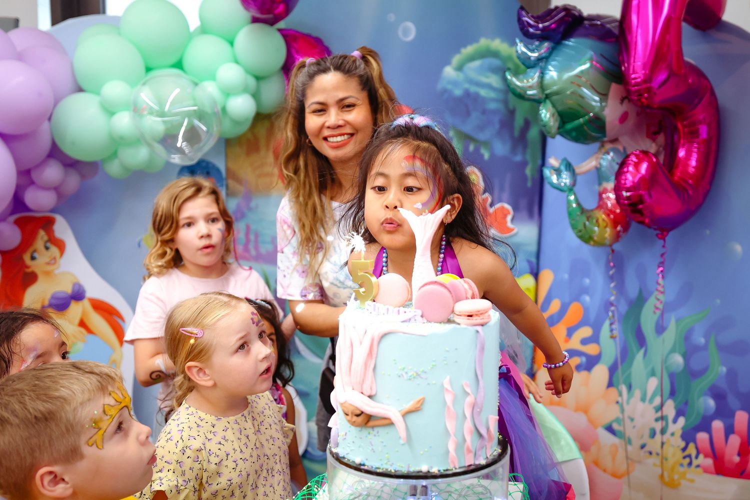 Colorful balloon arch and party decorations with celebratory atmosphere.